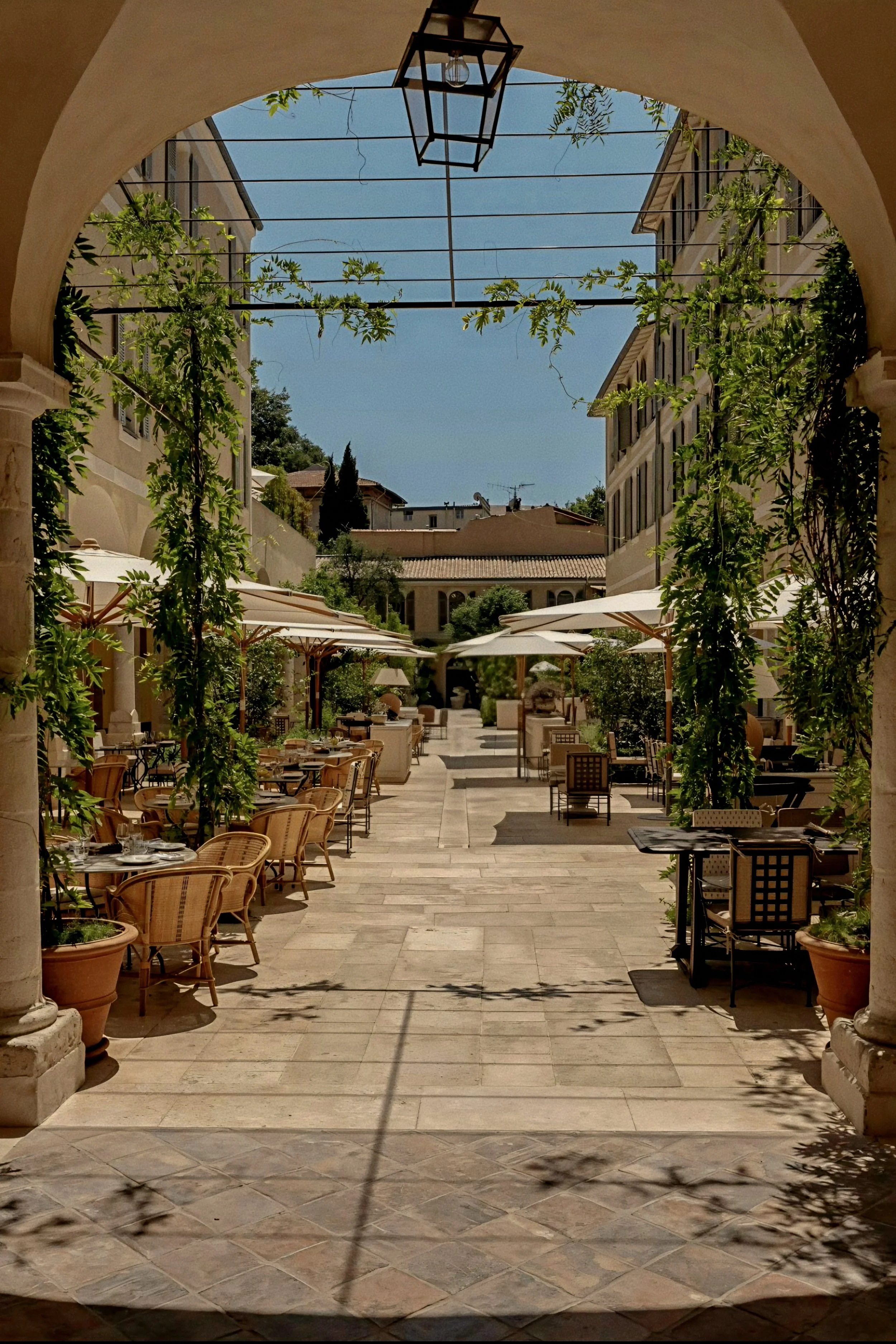 Stone arch arcade framing cloister courtyard at Hôtel du Couvent, a Luxury Collection Hotel, Nice, France.
