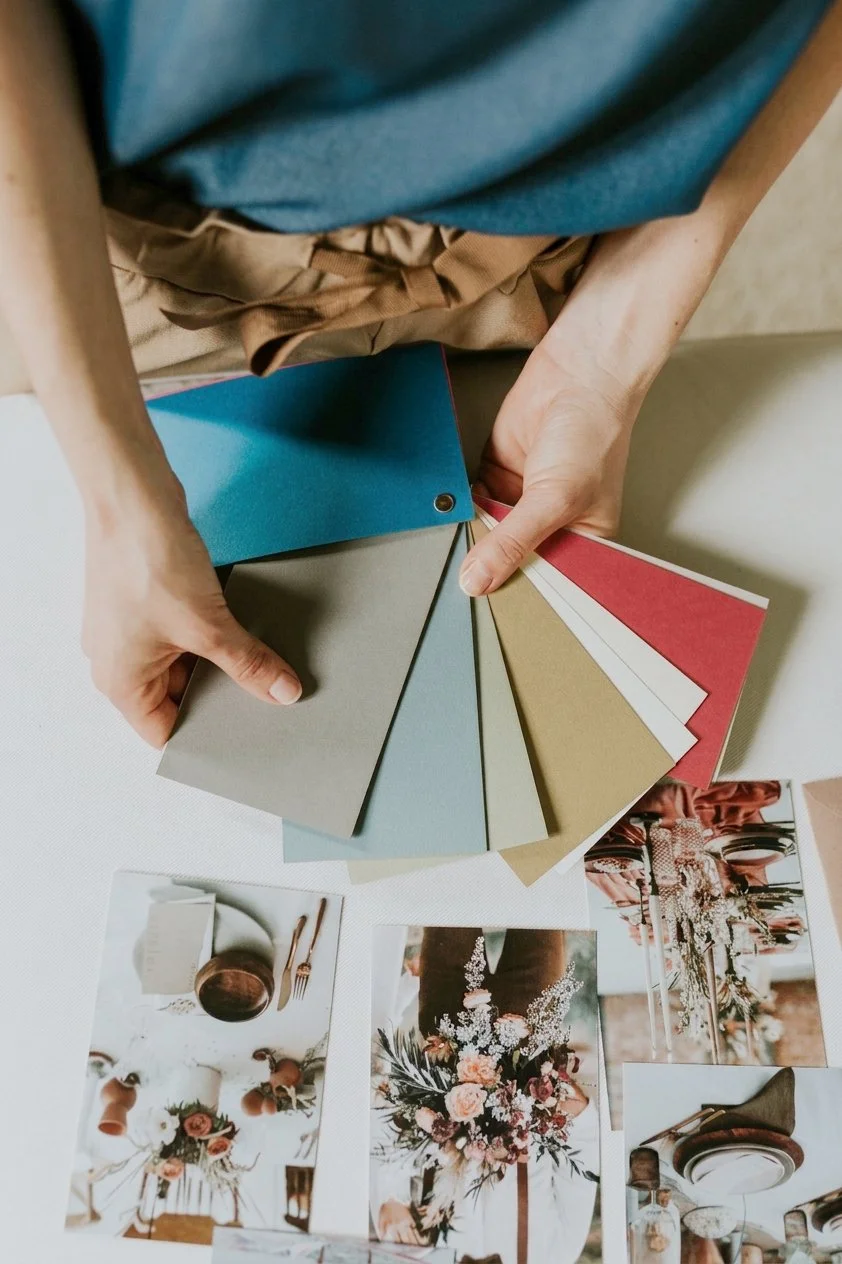 Una persona tiene in mano diversi campioni di carte colorate.