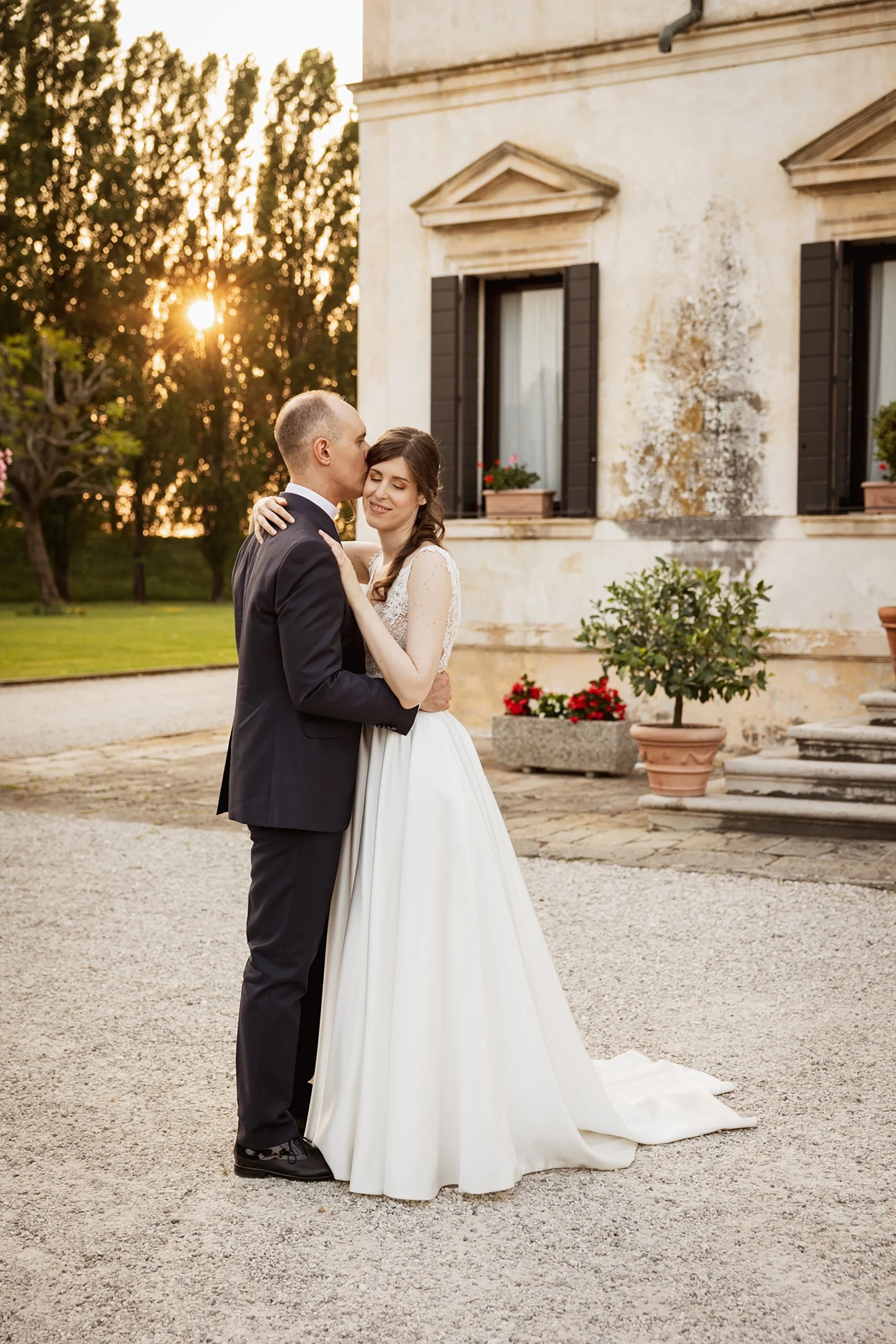 Gli sposi in un tenero bacio al tramonto