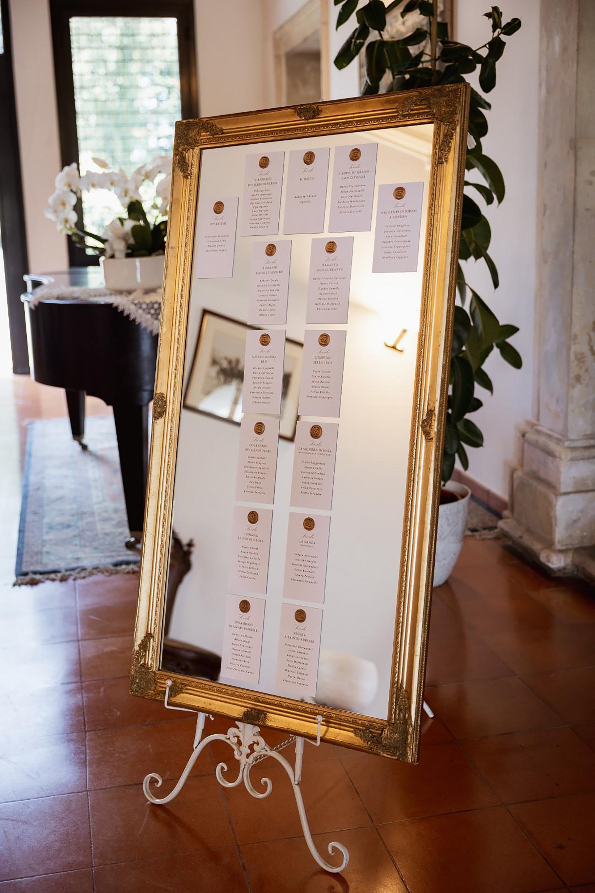 Uno specchio con cornice dorata vintage a Villa Ca' Marcello accoglie la disposizione dei tavoli