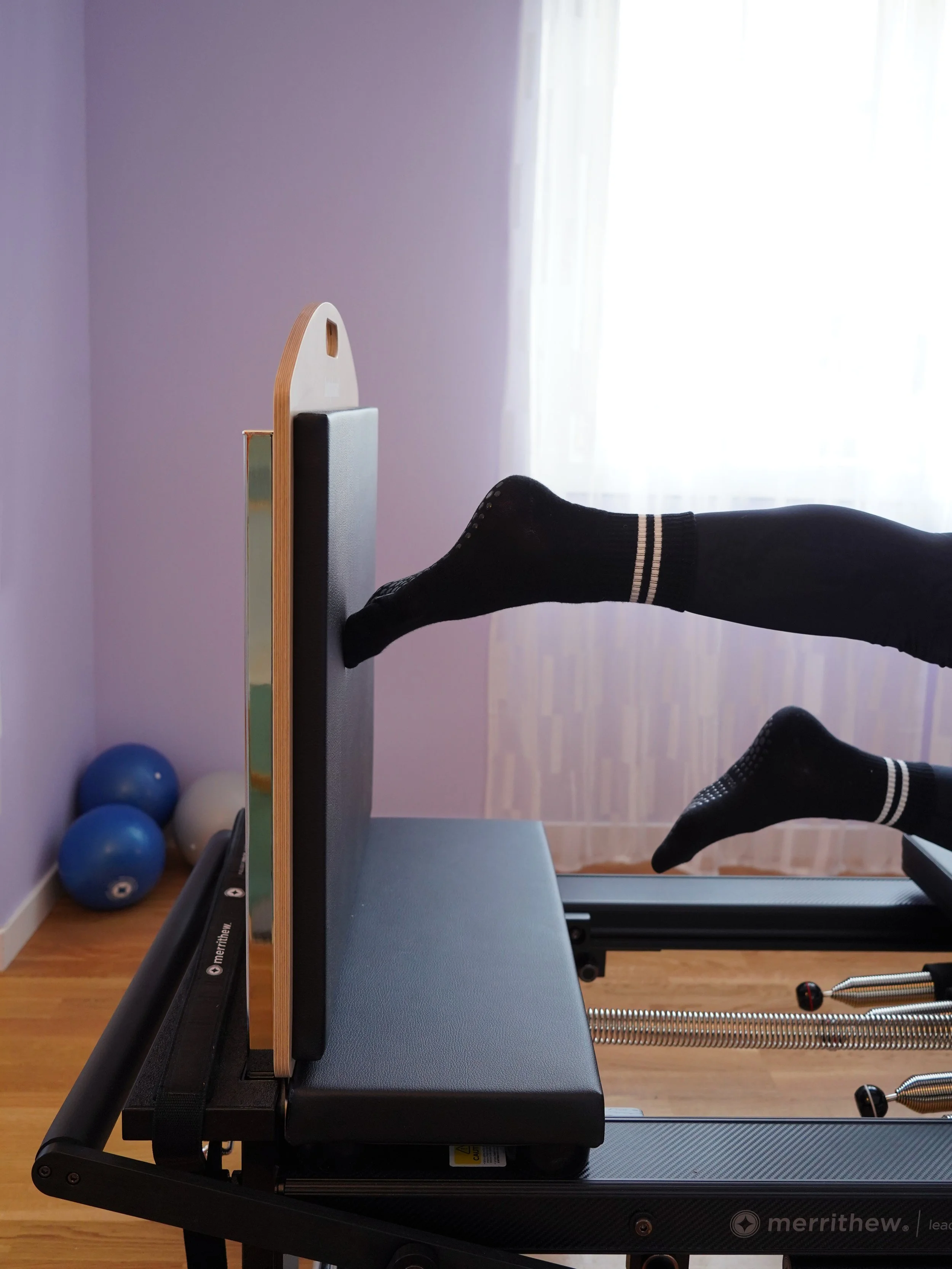 Woman on a Pilates Reformer pushing away jumpboard