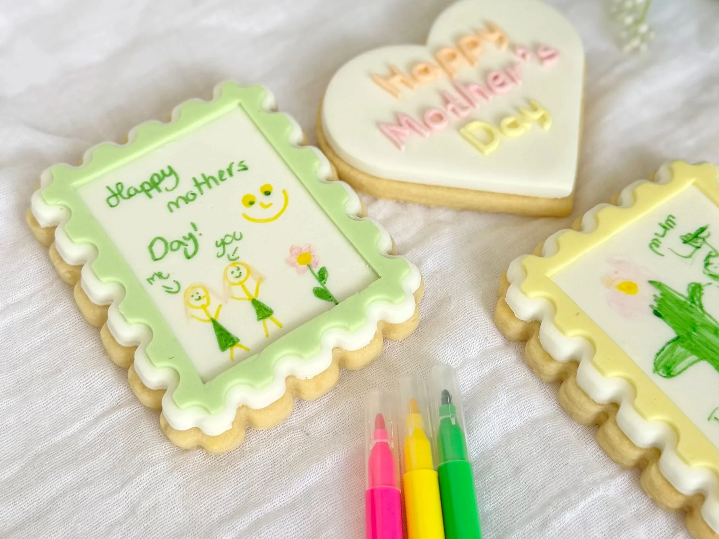 Decorated cookies with Mother's Day messages, colourful icing, along with coloured edible ink markers