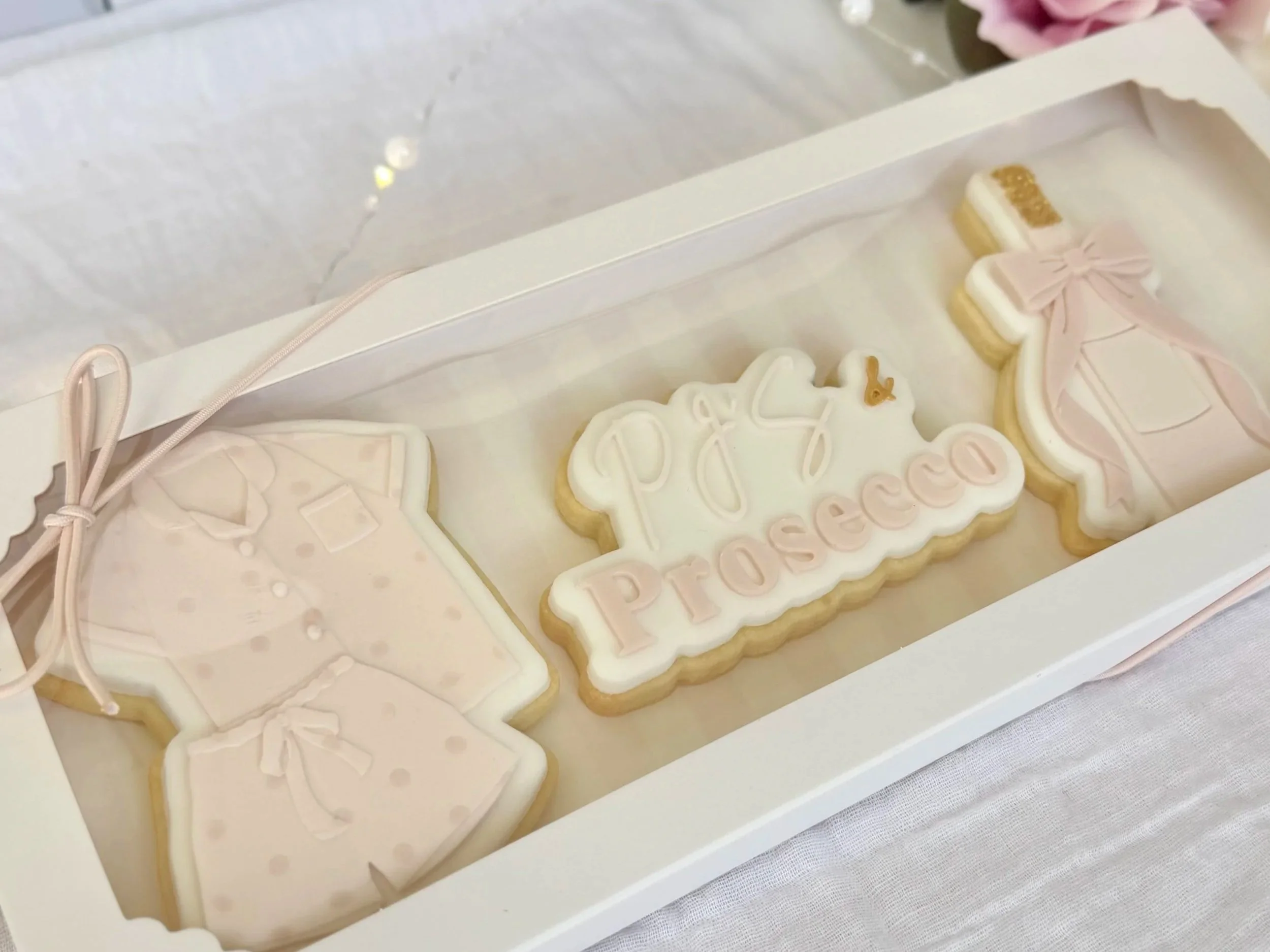 Decorative cookies in a white box, with a PJs and Prosecco theme for Mother's Day