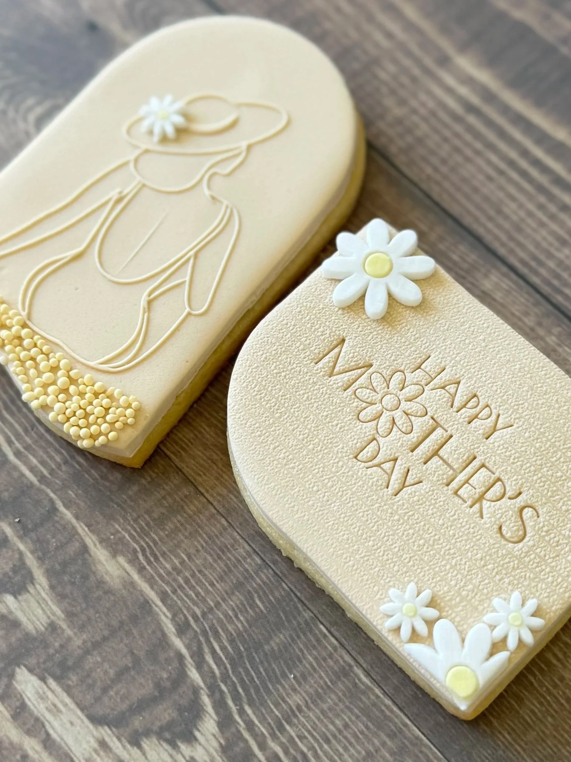An outline of a lady at the beach with a sunhat, with flower decorations and the words 'Mother's Day'