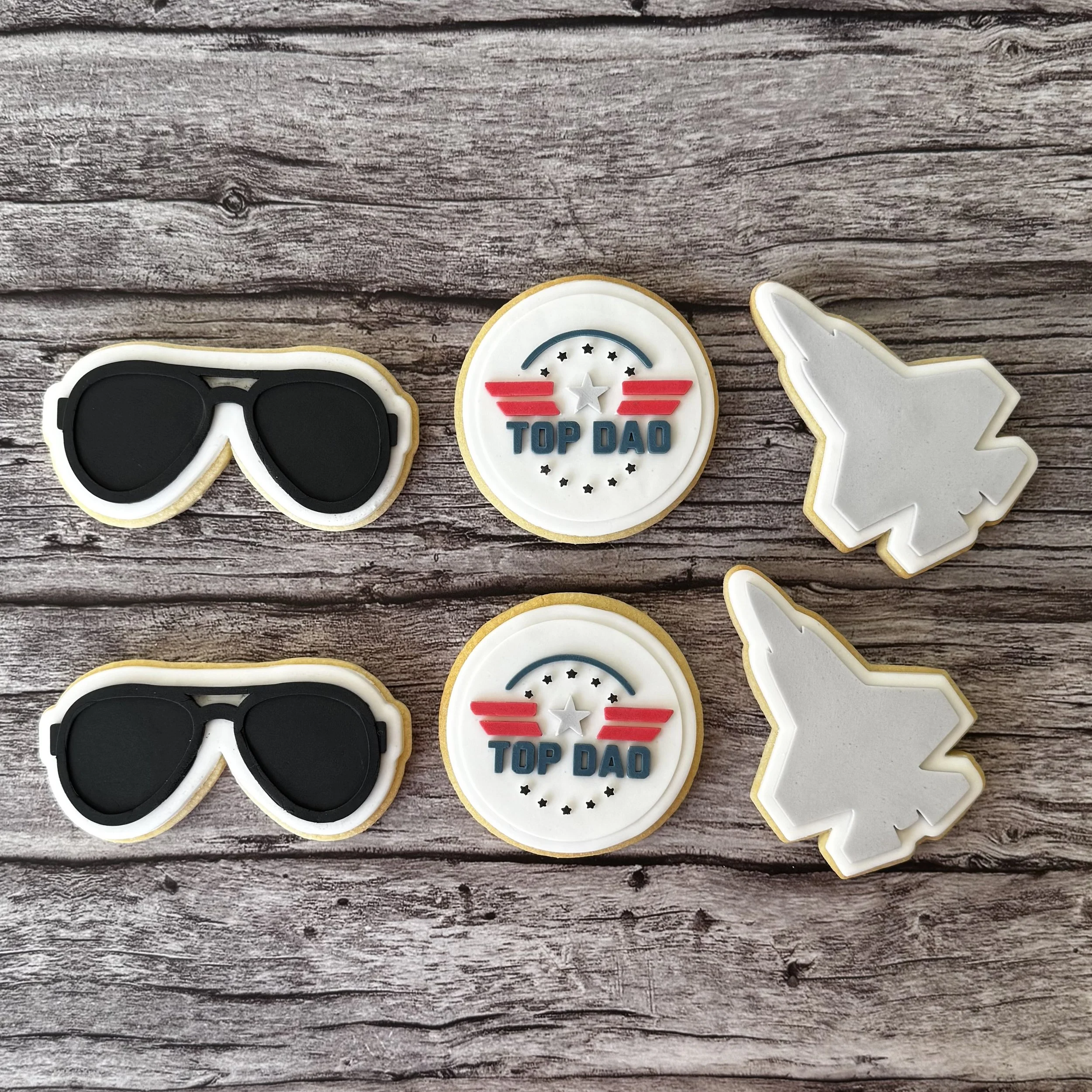 Decorative cookies with sunglasses, a 'Top Dad' emblem, and a jet