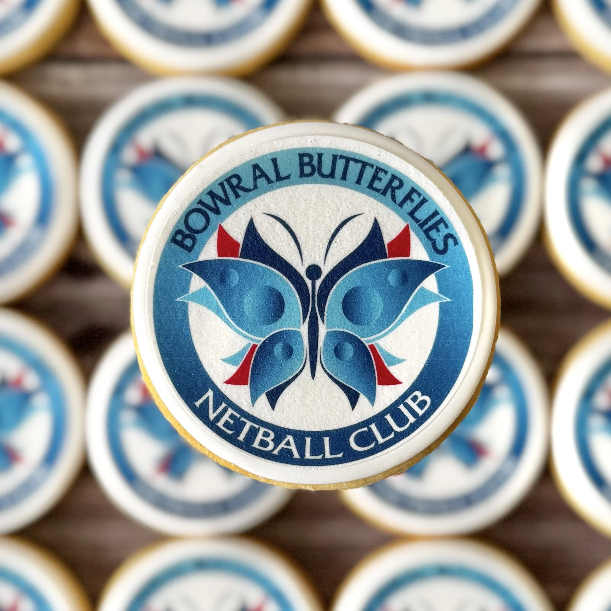 Close-up of a stack of cookies for end of season netball treats featuring 'Bowral Butterflies Netball Club'