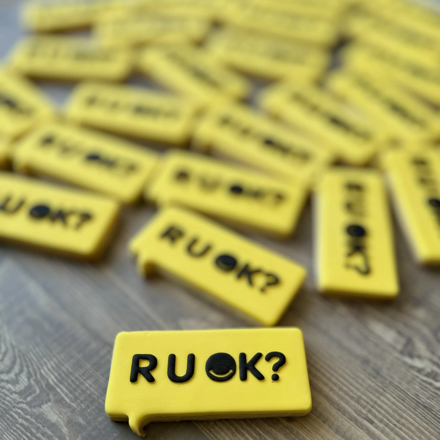 Yellow cookie with black text that reads "RUOK?"