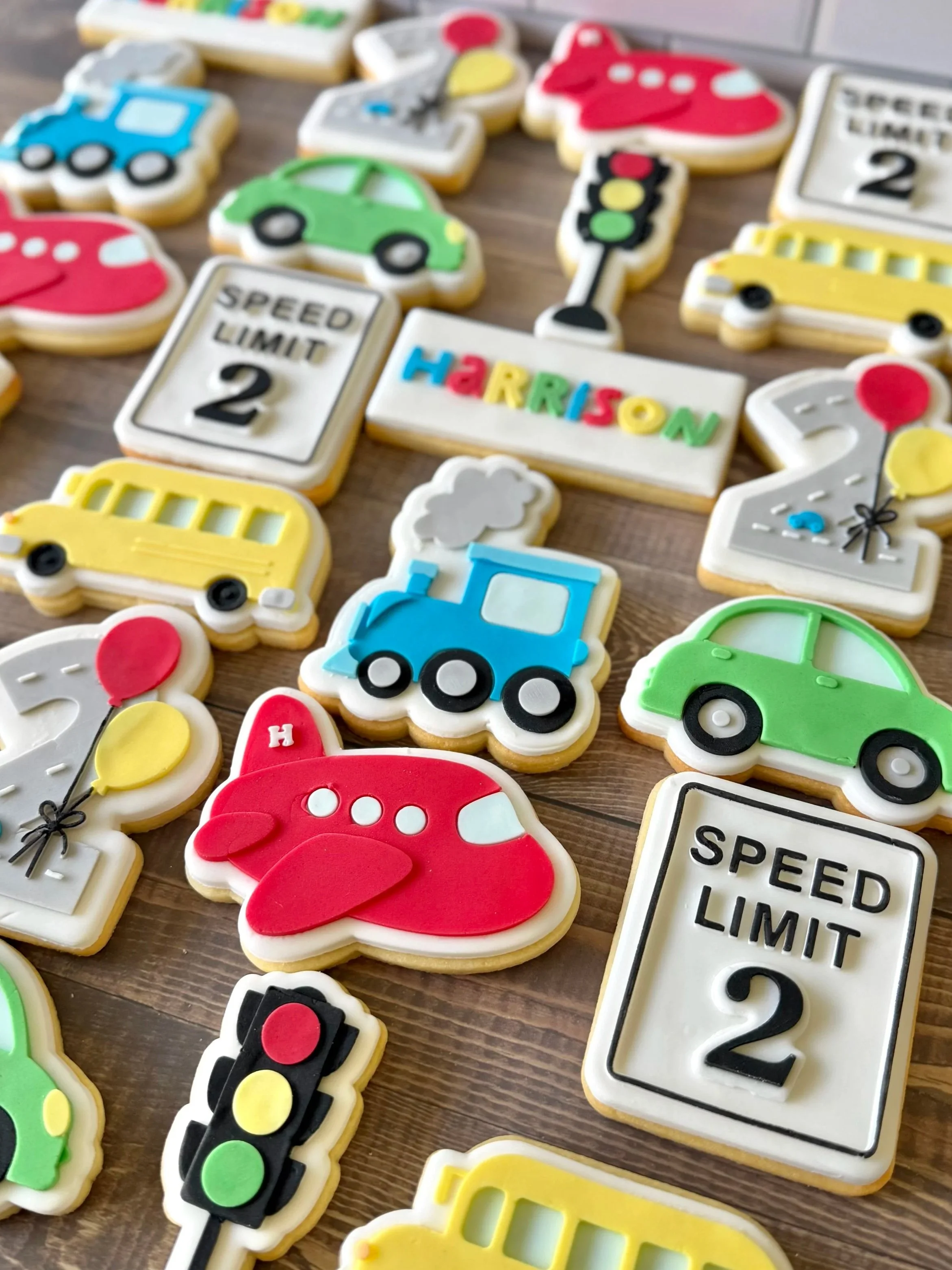 Construction-themed birthday cookies featuring cars, planes and road signs