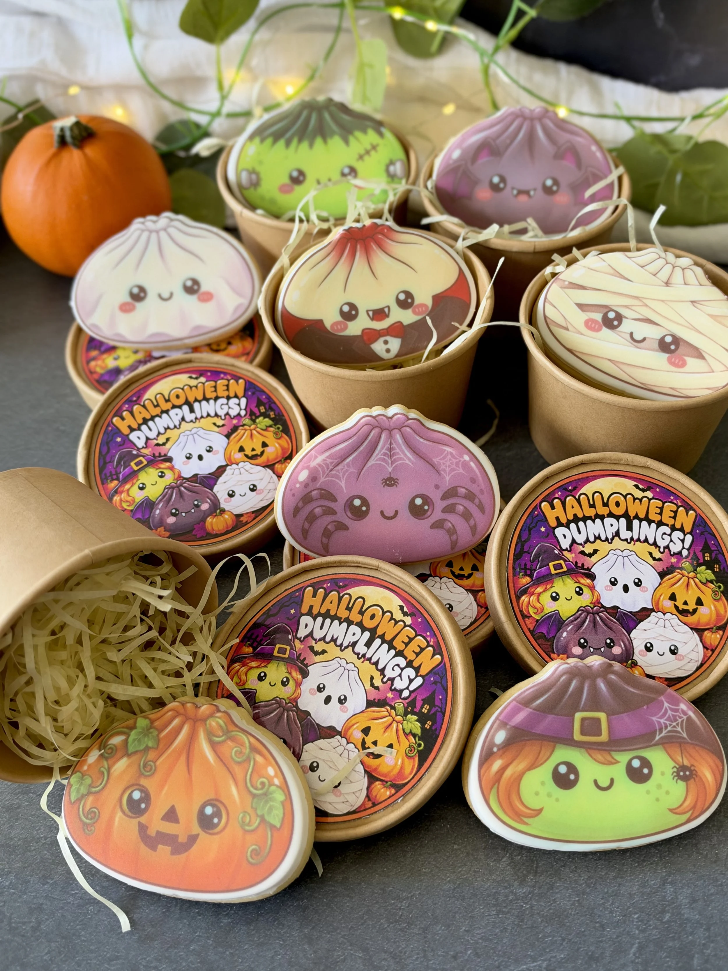 Halloween-themed dumpling sugar cookies with edible printed designs, presented in individual kraft mystery tubs