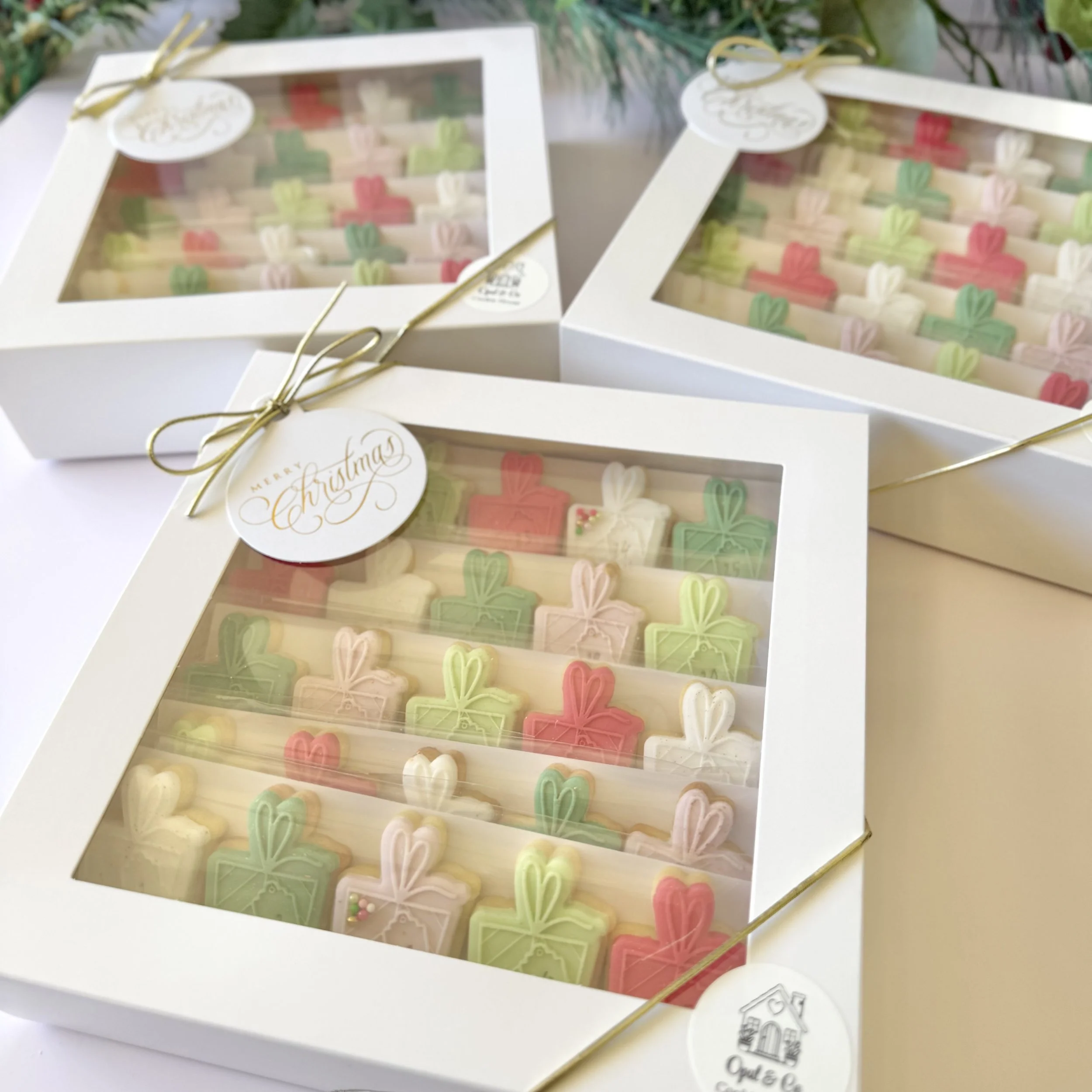 White gift box with a transparent top displaying colourful Christmas advent cookie calendars