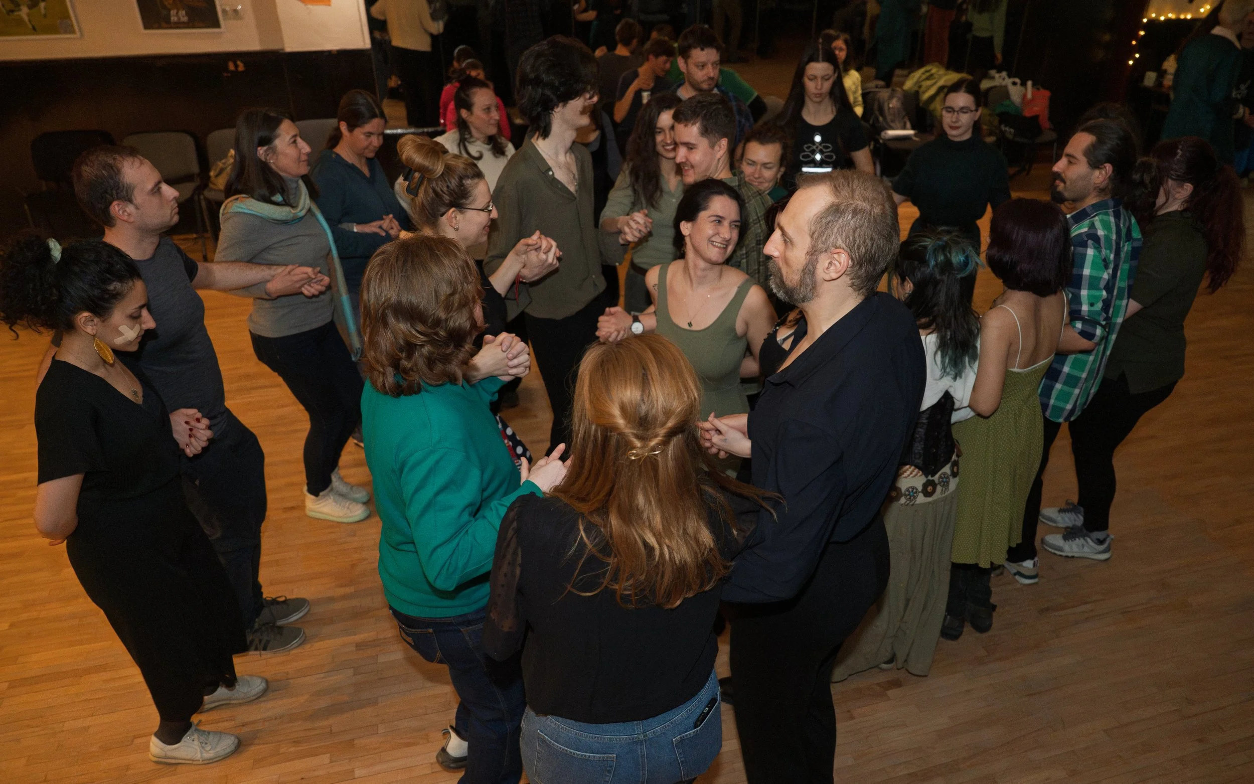 People dancing in a circle at a social gathering or party.