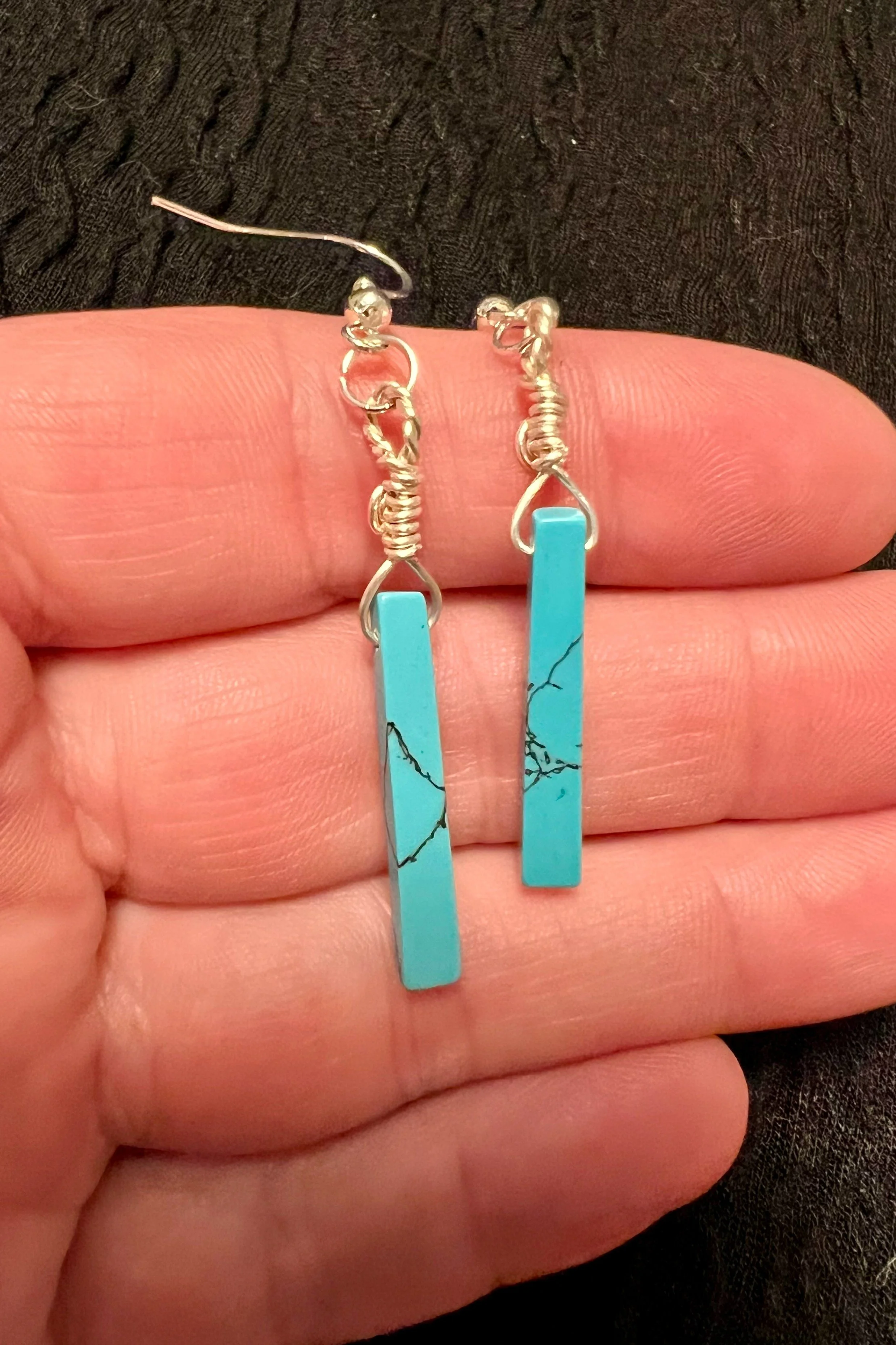 back side view of Handmade genuine turquise wire wrapped dangle earrings crafted with nickel free tarnish resistant silver colored wire and sterling silver hooks