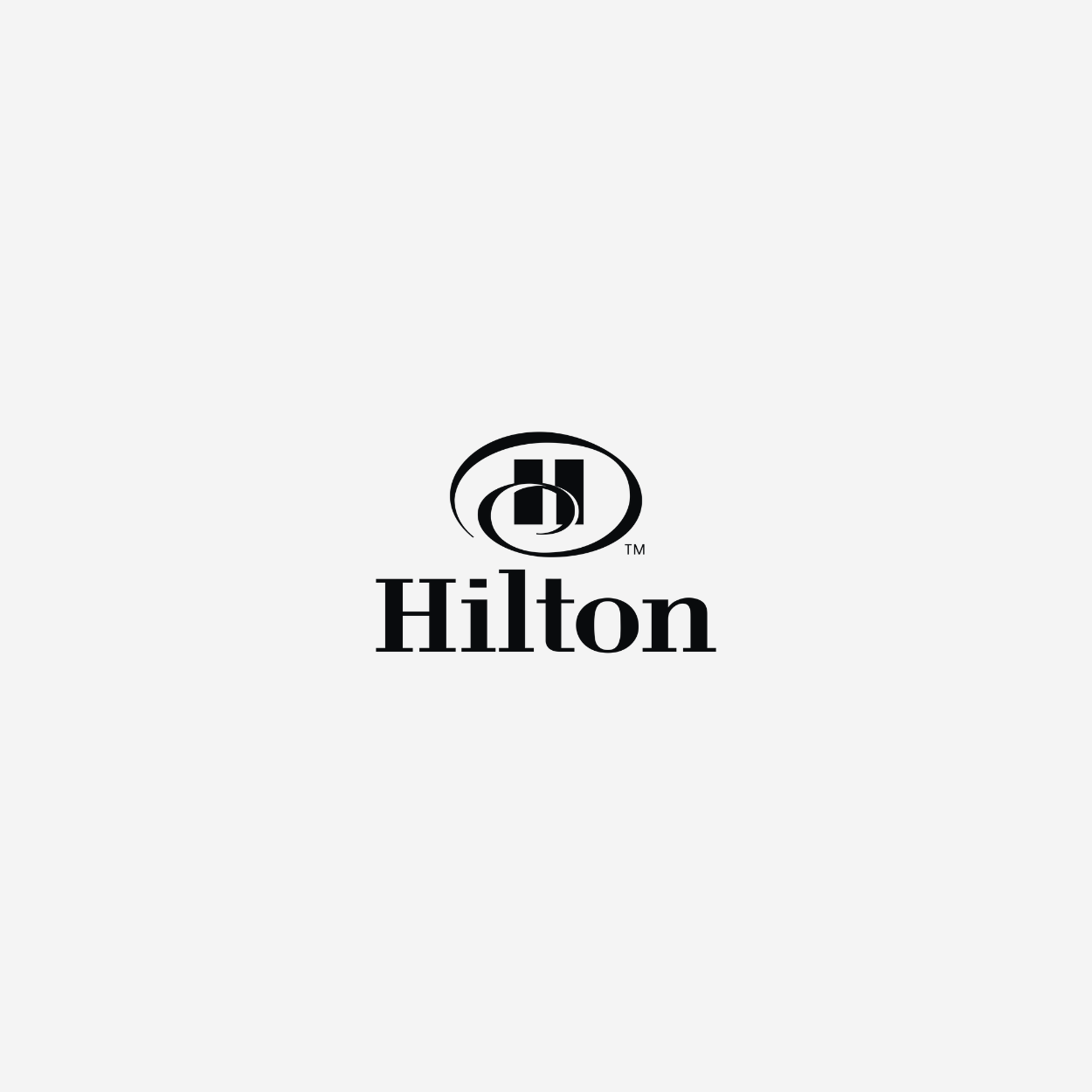 Hilton logo with a black and white circular emblem and the word 'Hilton' written below it.