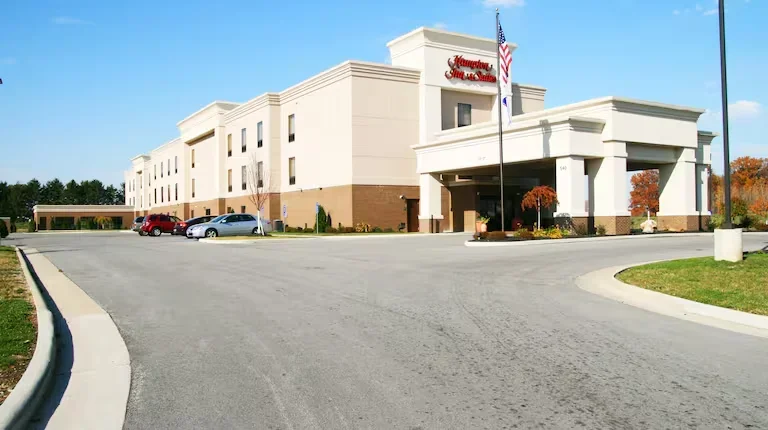 Hampton Inn hotel with a flagpole and parking lot.