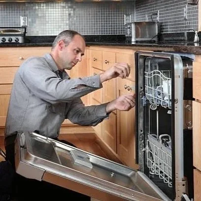 A man installing or repairing a dishwasher in a kitchen.