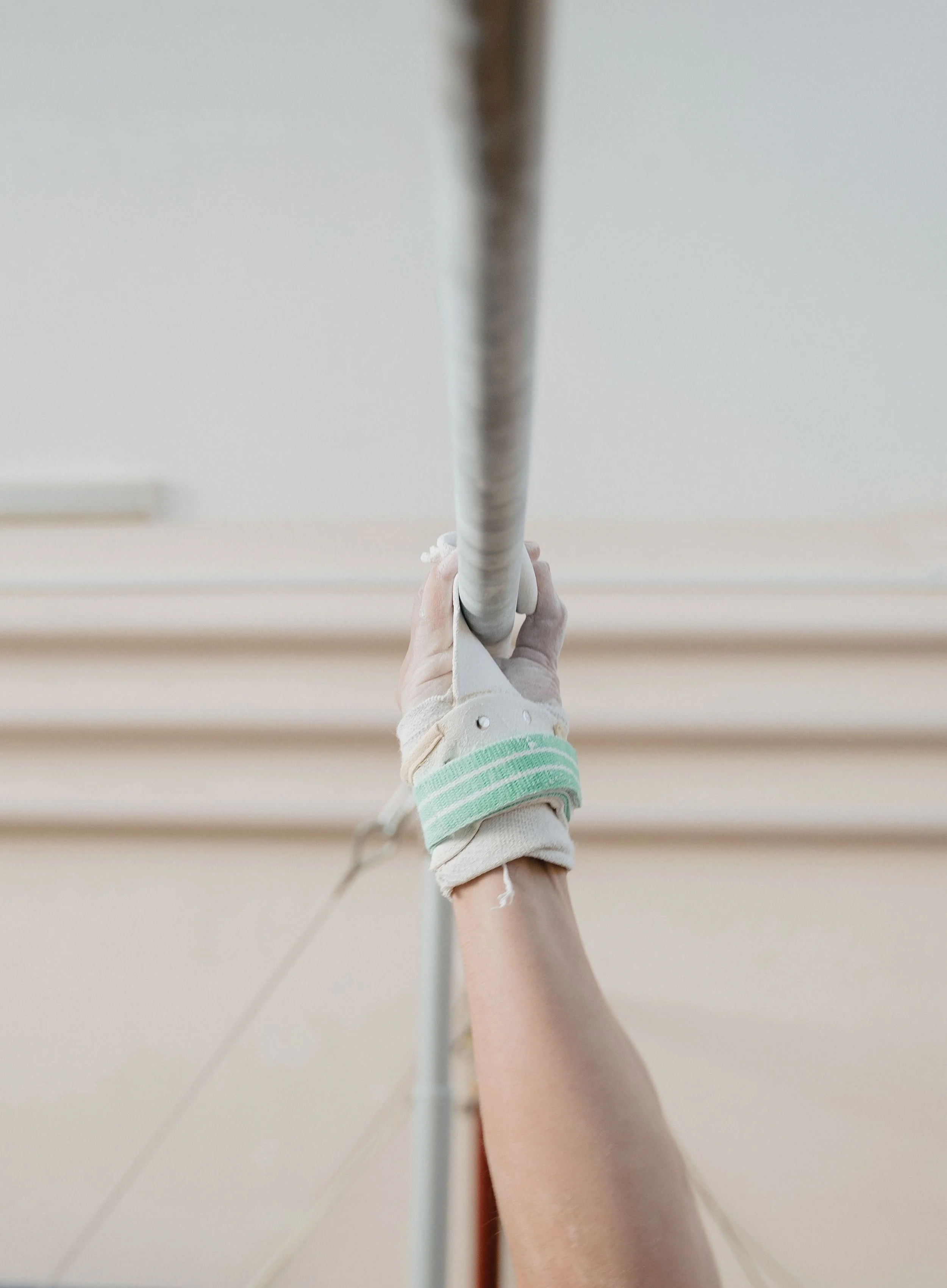A hand holding an IV drip in a hospital room.