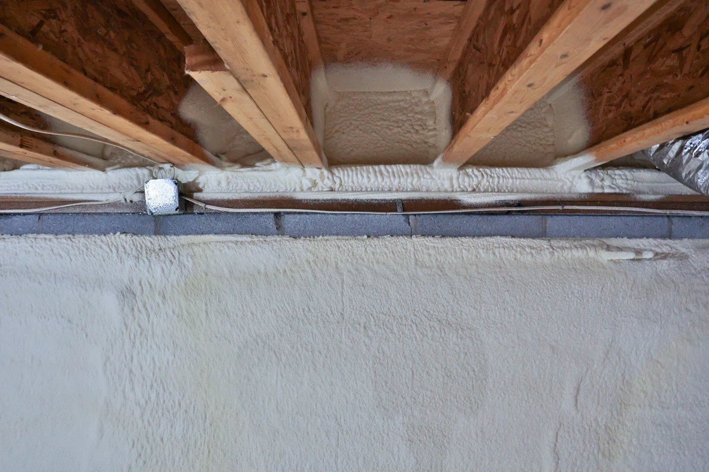 The rim joist runs the whole way around a house, right where the floor framing lands on the foundation. It's a continuous seam, and every bay along it is a gap between the crawl space and the room above. Foam in the bays, foam down the top of the blo