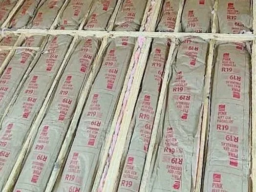 Stacks of newspapers or magazines wrapped in plastic, arranged in rows on a shelf.