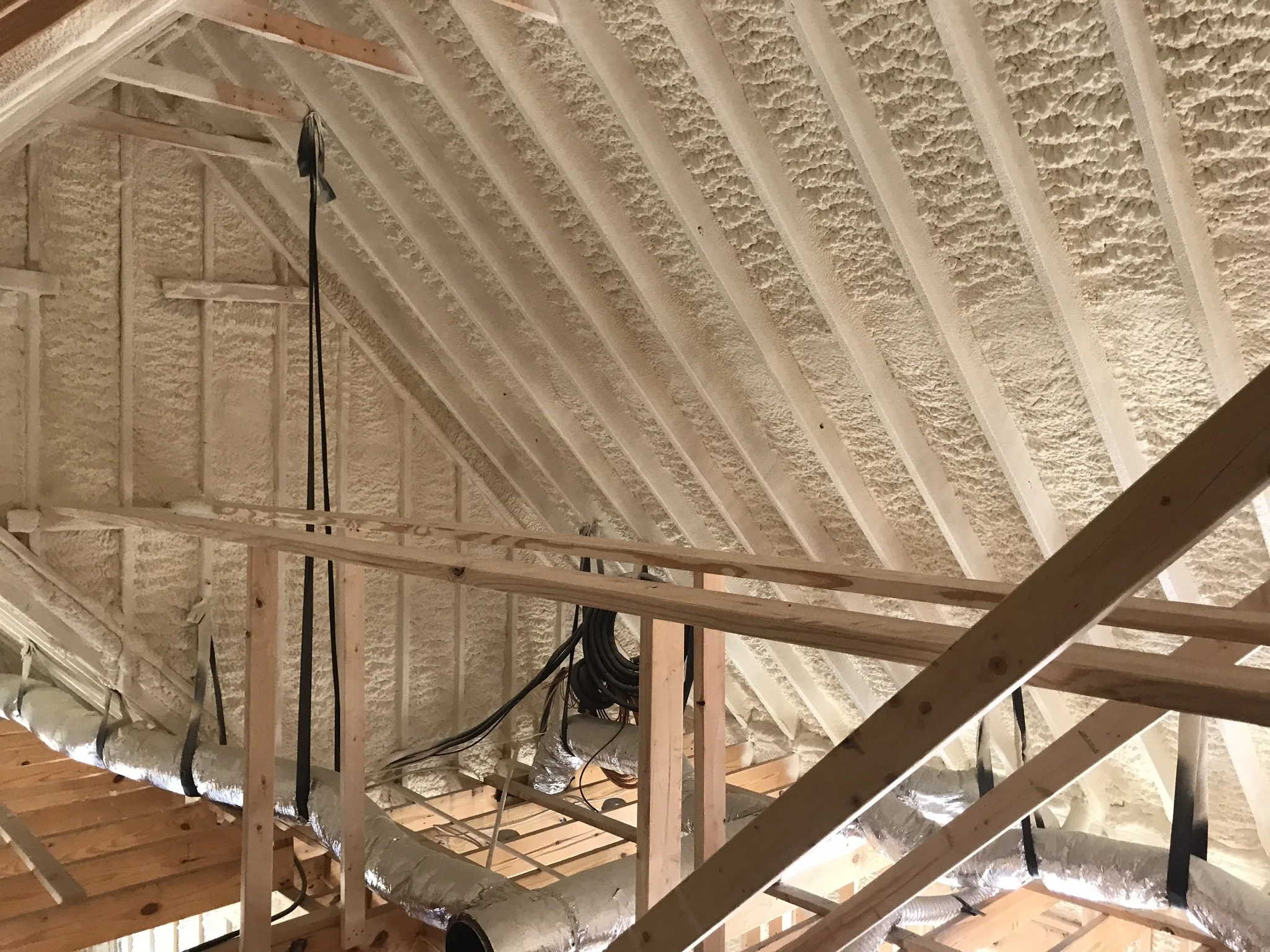 Construction framing of a ceiling with insulation and ductwork visible.