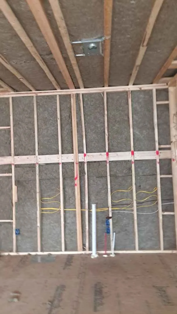 Interior of a room under construction showing framing and Rockwool insulation
