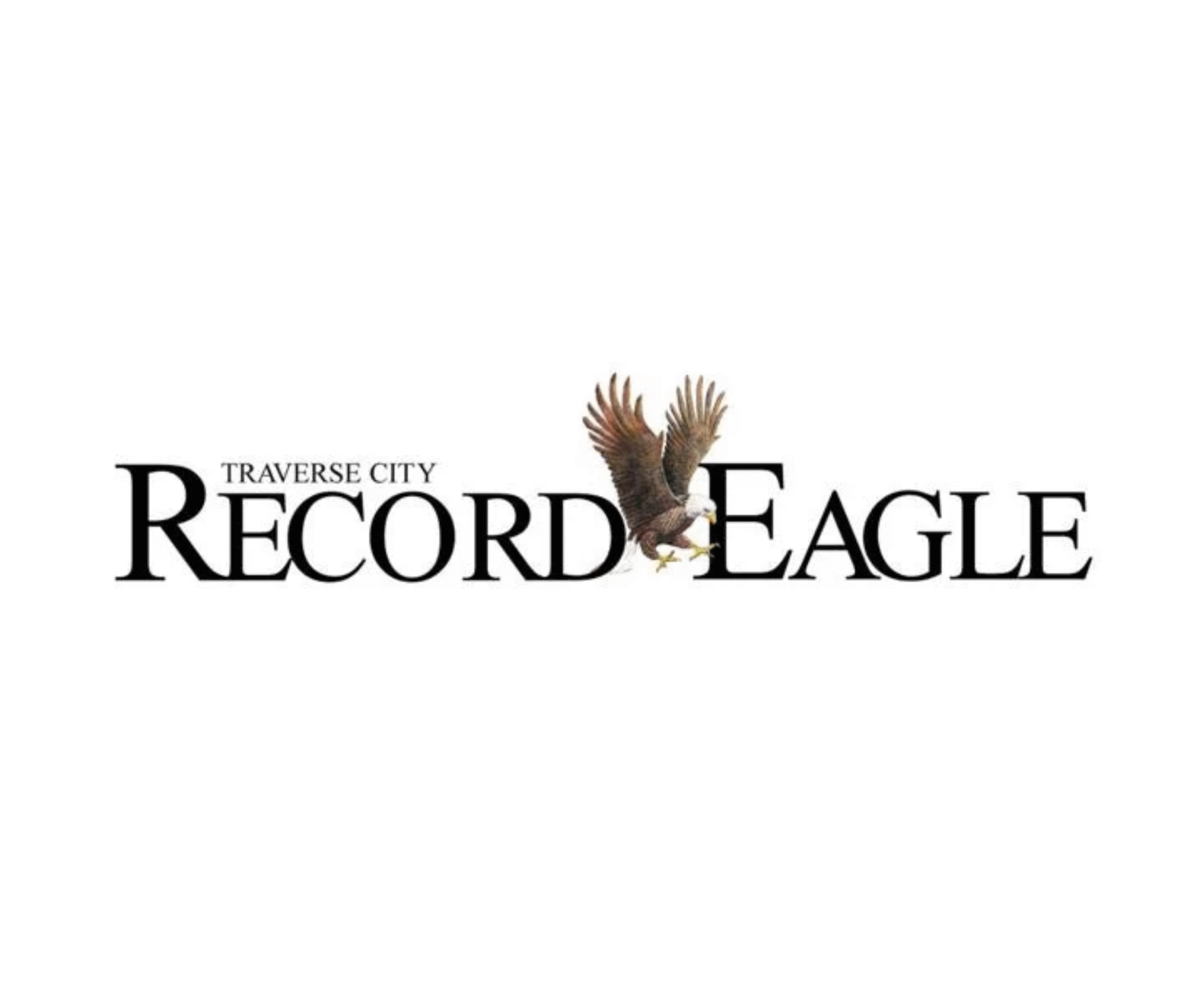 An eagle with outstretched wings is perched on the text 'Traverse City Record-Eagle' on a white background.