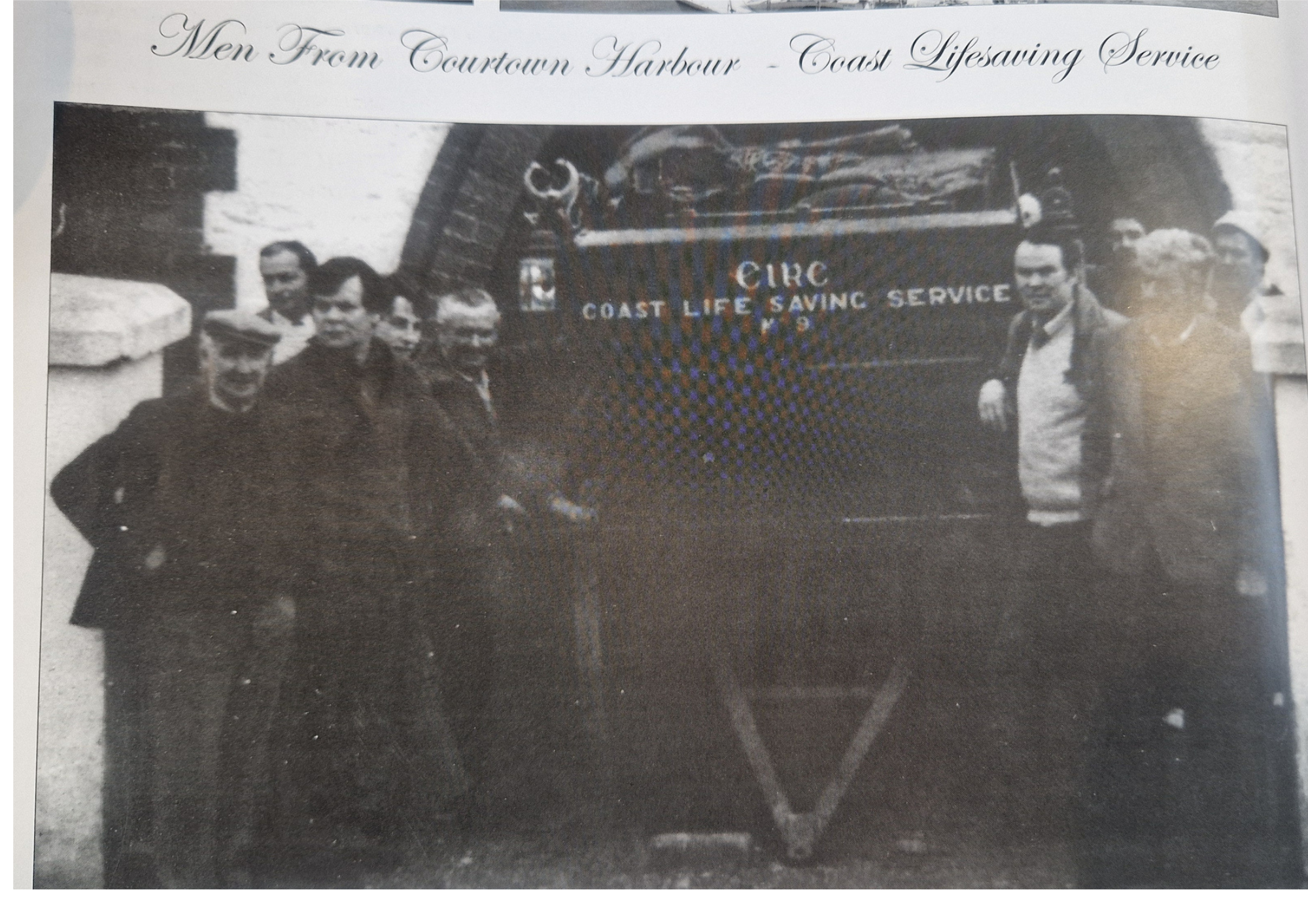 Black and white photograph of several men standing in front of a Coast Guard Life Saving Service truck. The men are dressed in coats and hats, and are positioned around the truck, which has the words 'Coast Guard' and 'Coast Life Saving Service' writ