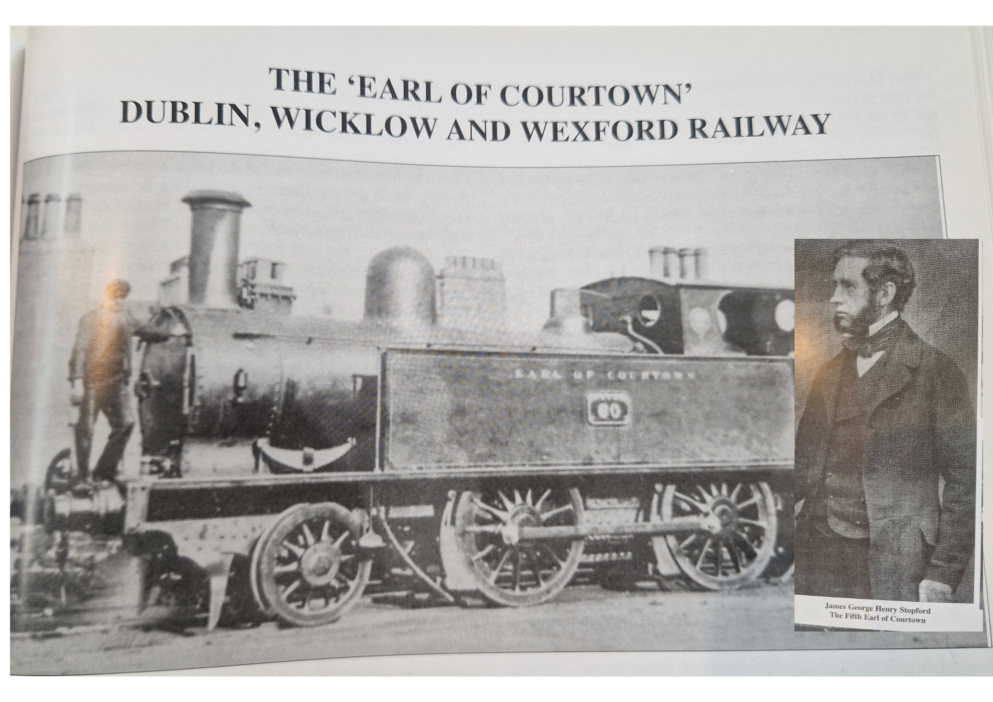 Black and white historical photograph of a steam locomotive train with four large wheels and prominent chimney, positioned behind a sign reading 'Gates of Courtown'. A man in vintage clothing stands beside the train on the left. A portrait of James G
