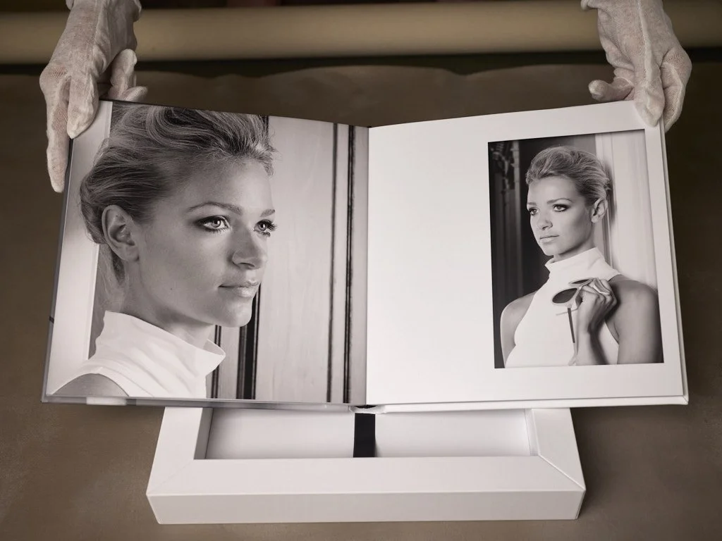 Black and white photo book showing portraits of a woman, with hair styled up, in a sleeveless top.
