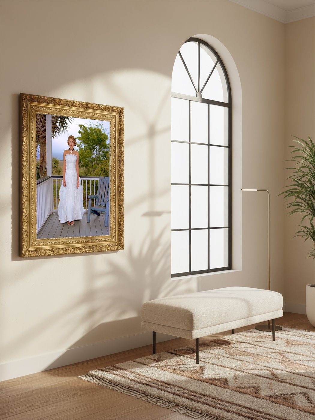 A mirror on a beige wall reflects a woman in a white wedding dress standing on a porch with a wooden deck, greenery, and an outdoor chair.