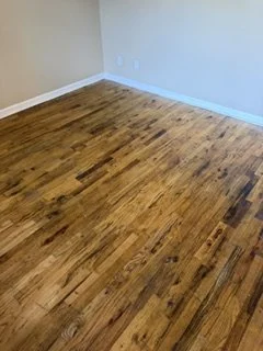 Empty room with hardwood floor and white walls.