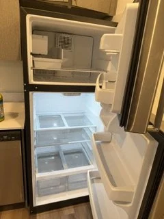 Open empty refrigerator with shelves and freezer compartments
