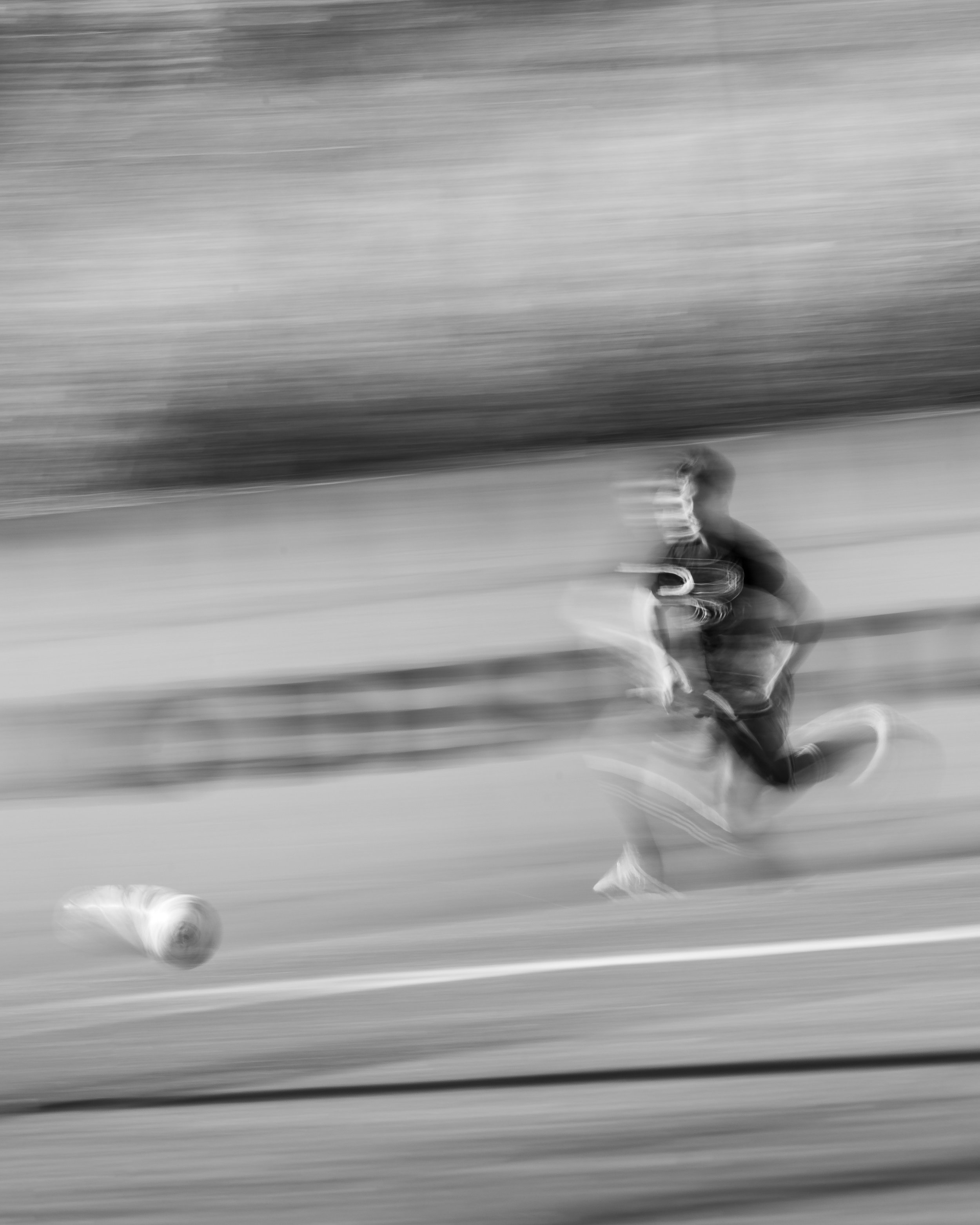A blurred black-and-white photo of a person running on a football field.
