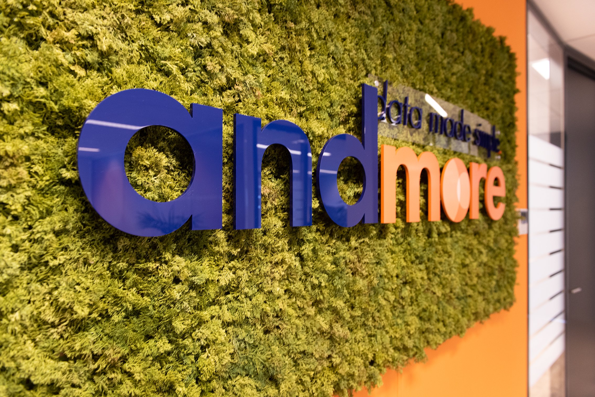 Een groene muur met het Andmore logo