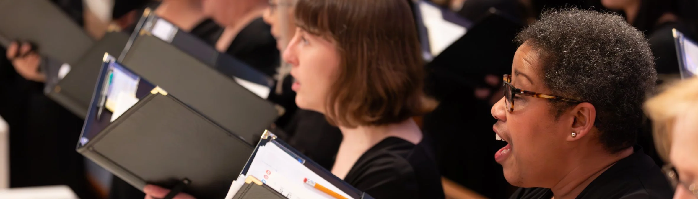 Close-up of chorus members singing.