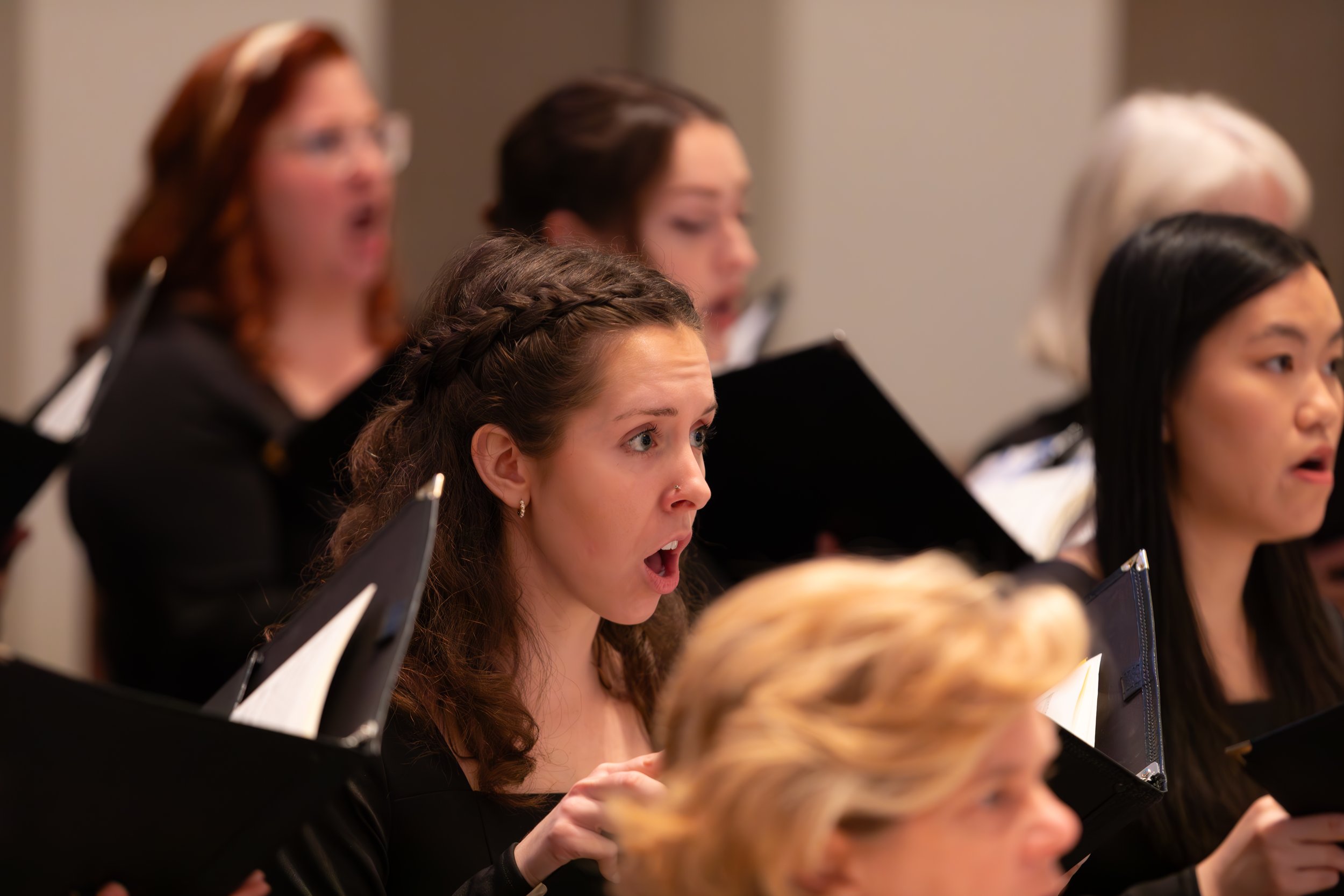 Close-up of chorus members singing.