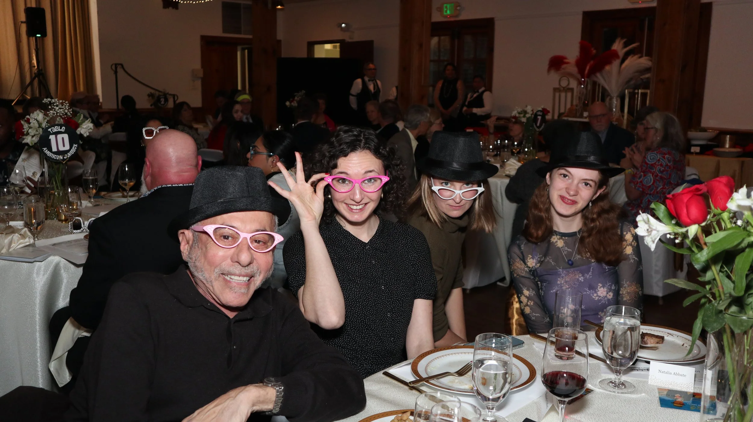 Smiling party-goers wearing silly cat's-eye glasses.