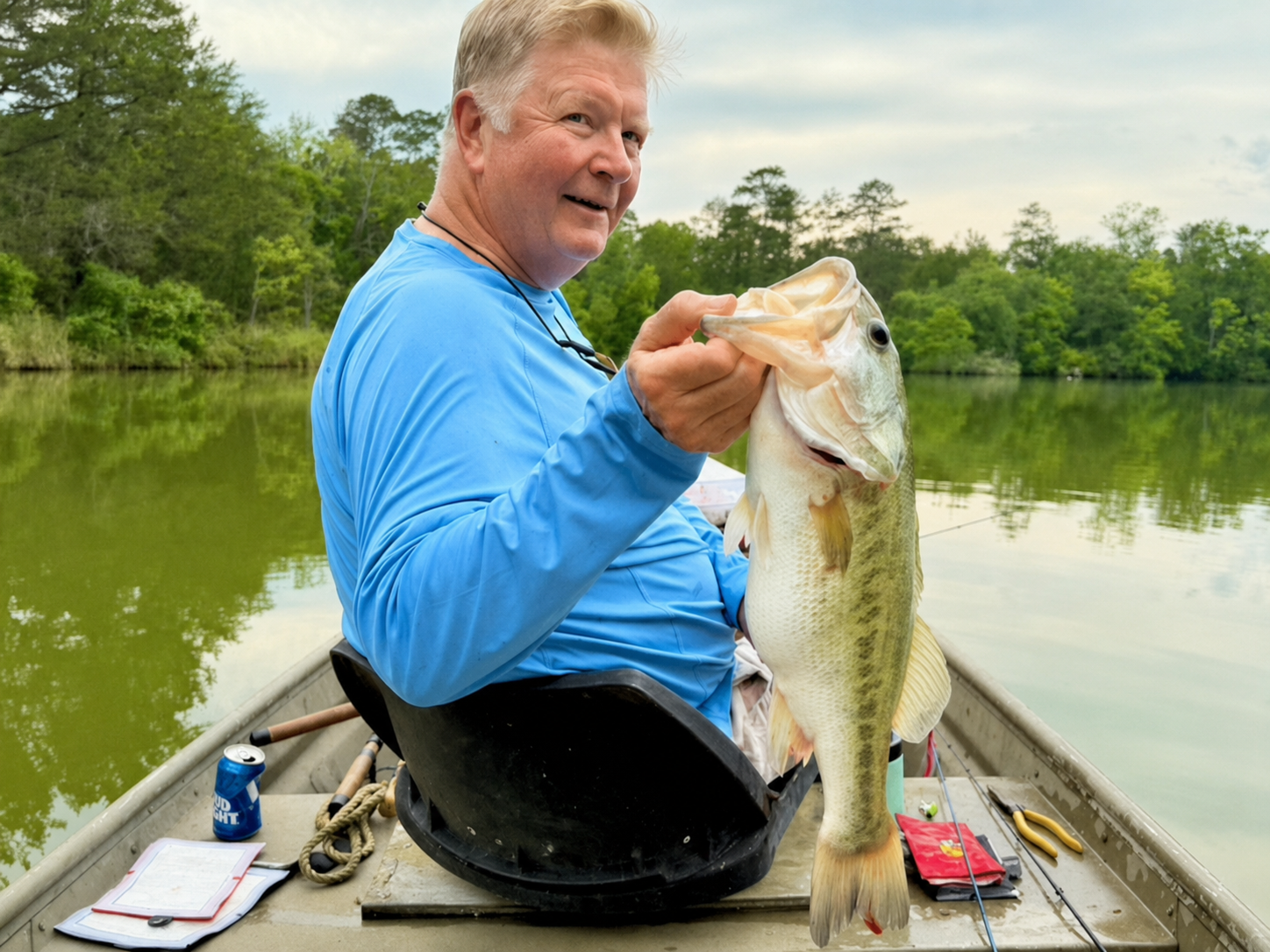 Rush Rice smiling on boat holding a large fish he caught.