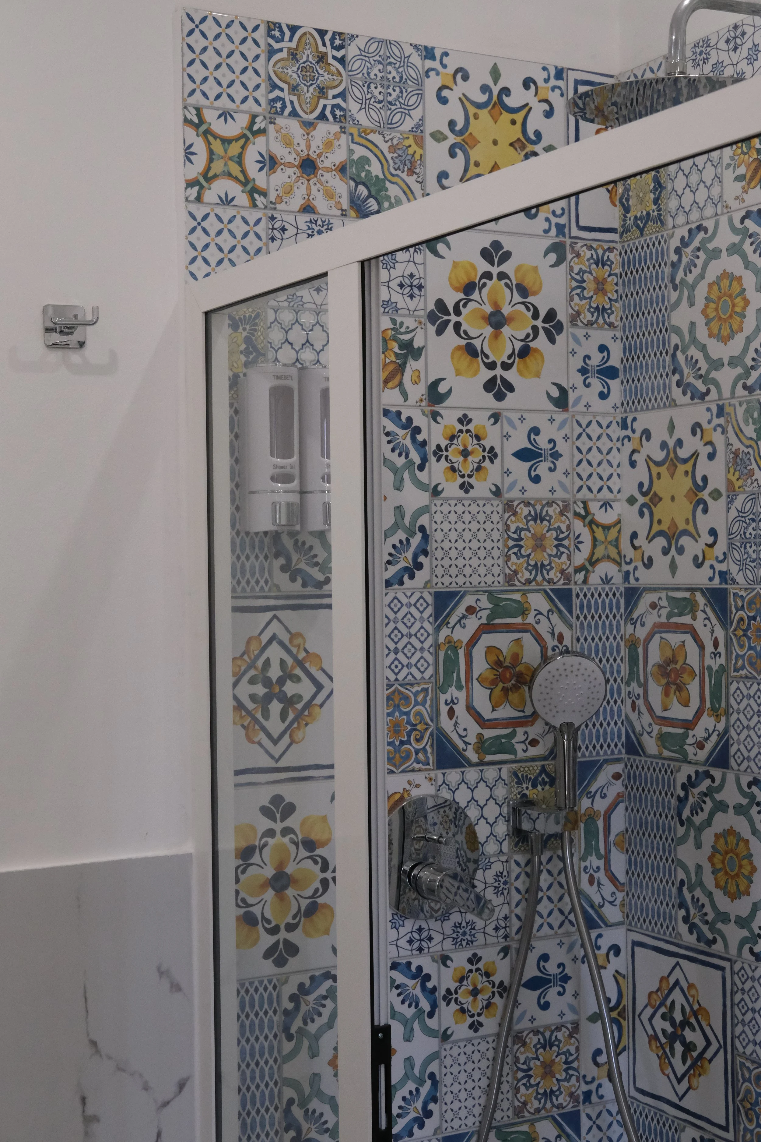 Doccia in bagno decorata con piastrelle colorate con motivi geometrici e floreali