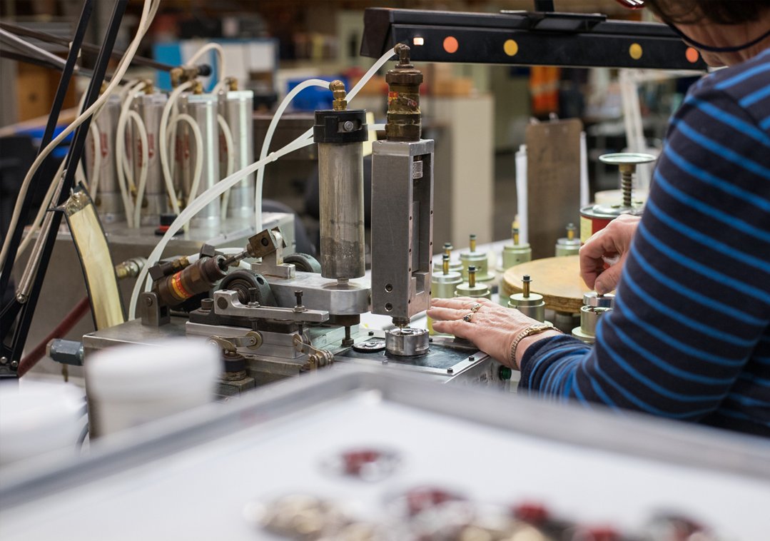 Person working with machinery in a workshop, assembling electronic components.