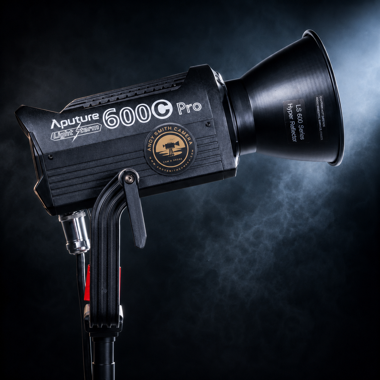A professional studio strobe light with a black body labeled 'Aputure 600d Pro' and a large reflector attachment, mounted on a stand against a dark background.