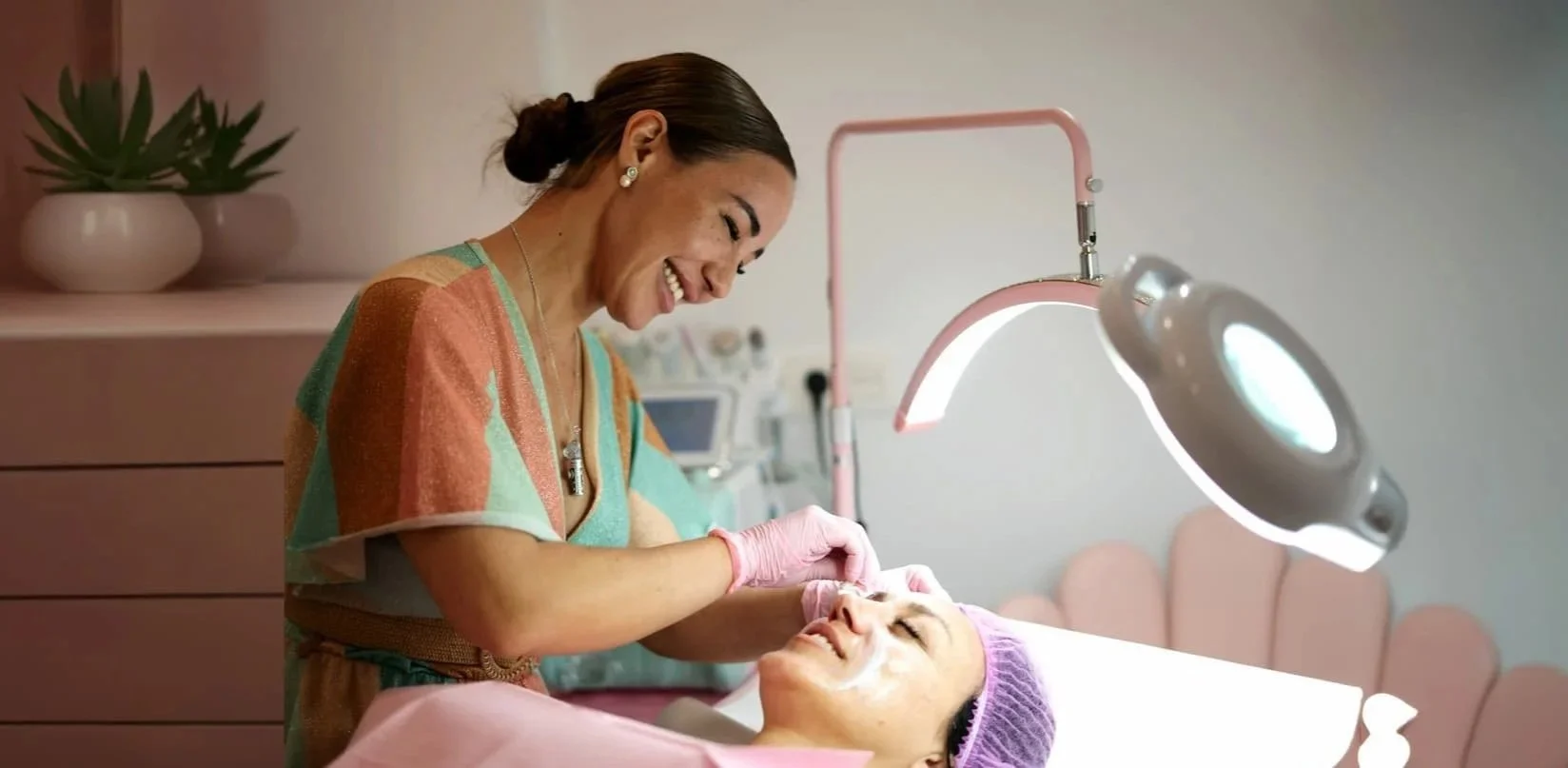 Skincare professional performing a facial treatment on a client.