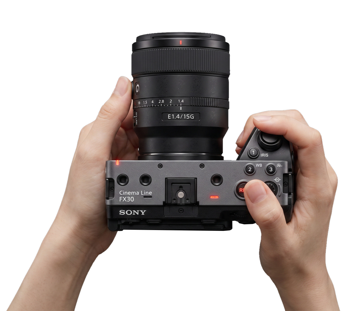 Hands holding a mirrorless camera with a large lens.