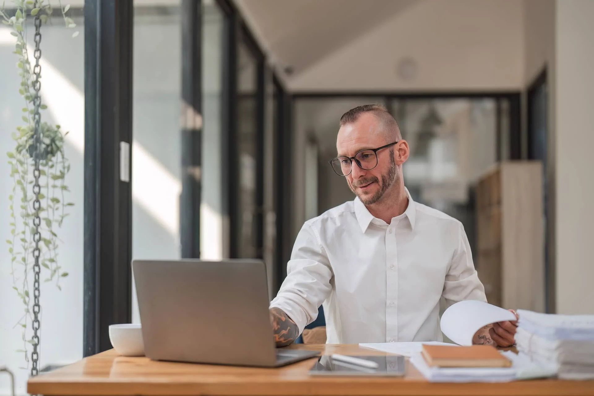 A man working on a laptop and papers. Man working on a company.