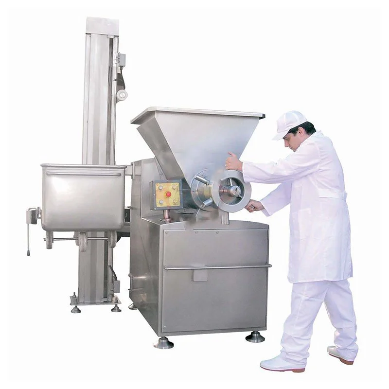 A man in a white lab coat and cap operating a large stainless steel industrial food grinder or pulverizer machine.