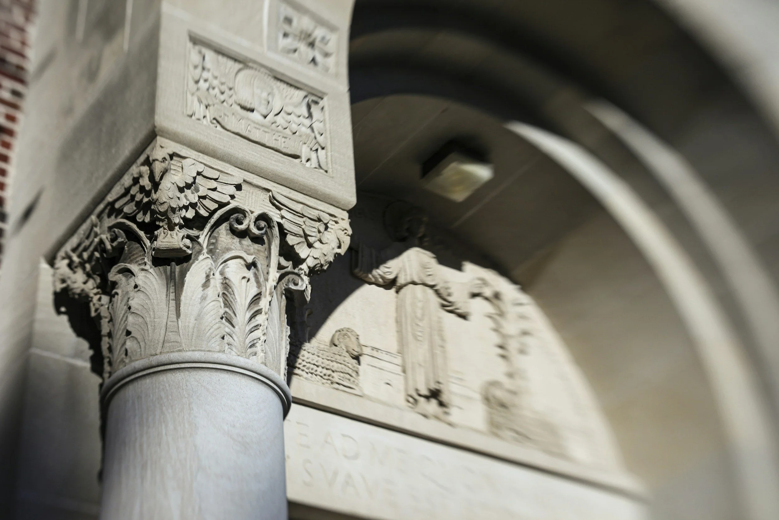 Close-up of decorative architectural details on a building, including ornate carvings and a column capital.