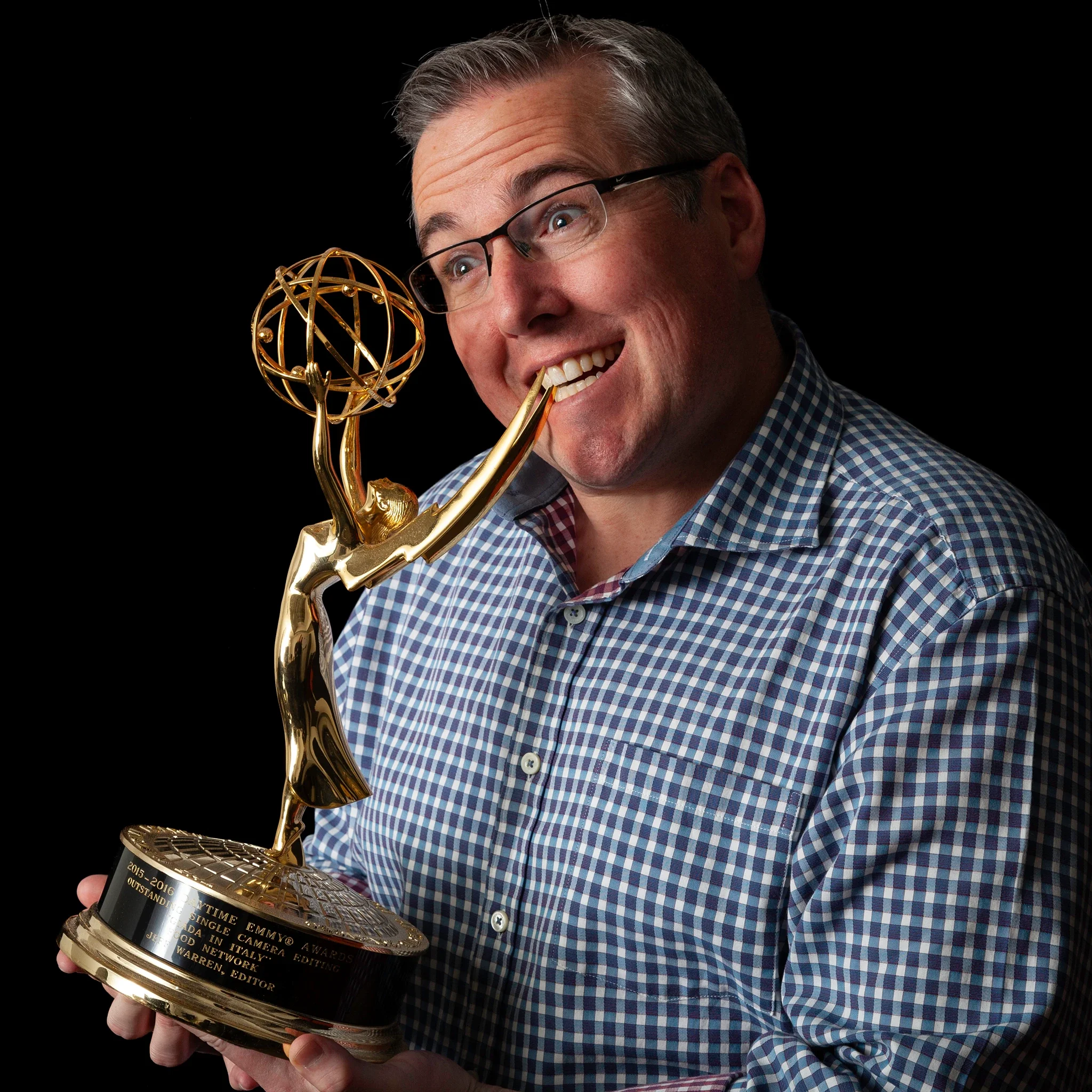 Neato Pictures — Funny Emmy win portrait,  Jeff Warren with award in hand, biting angel wing