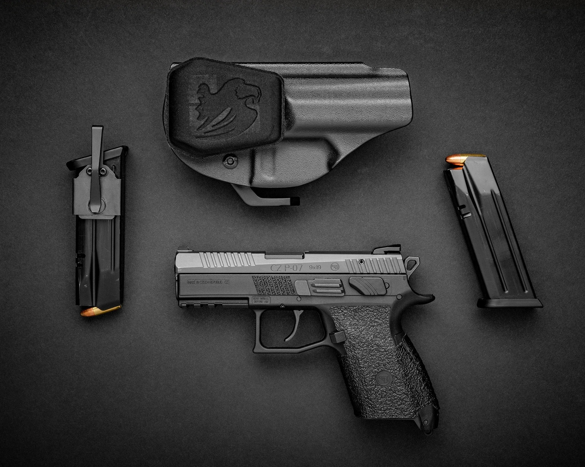 CZ P-07 EDC rig — pistol, magazines, and holster laid out on dark surface