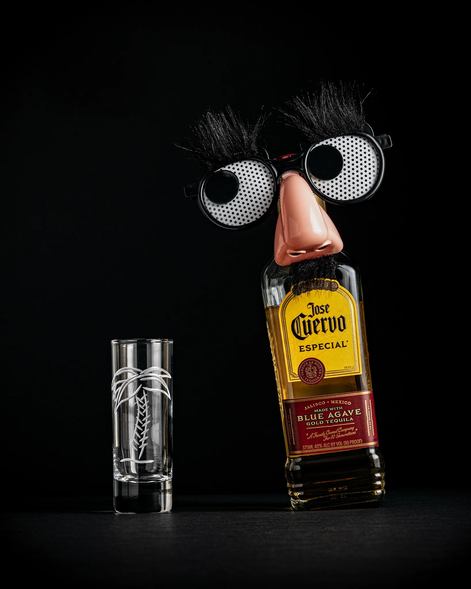 Jose Cuervo Especial Gold — tequila bottle beside etched shot glass with humorous Groucho Marx disguise