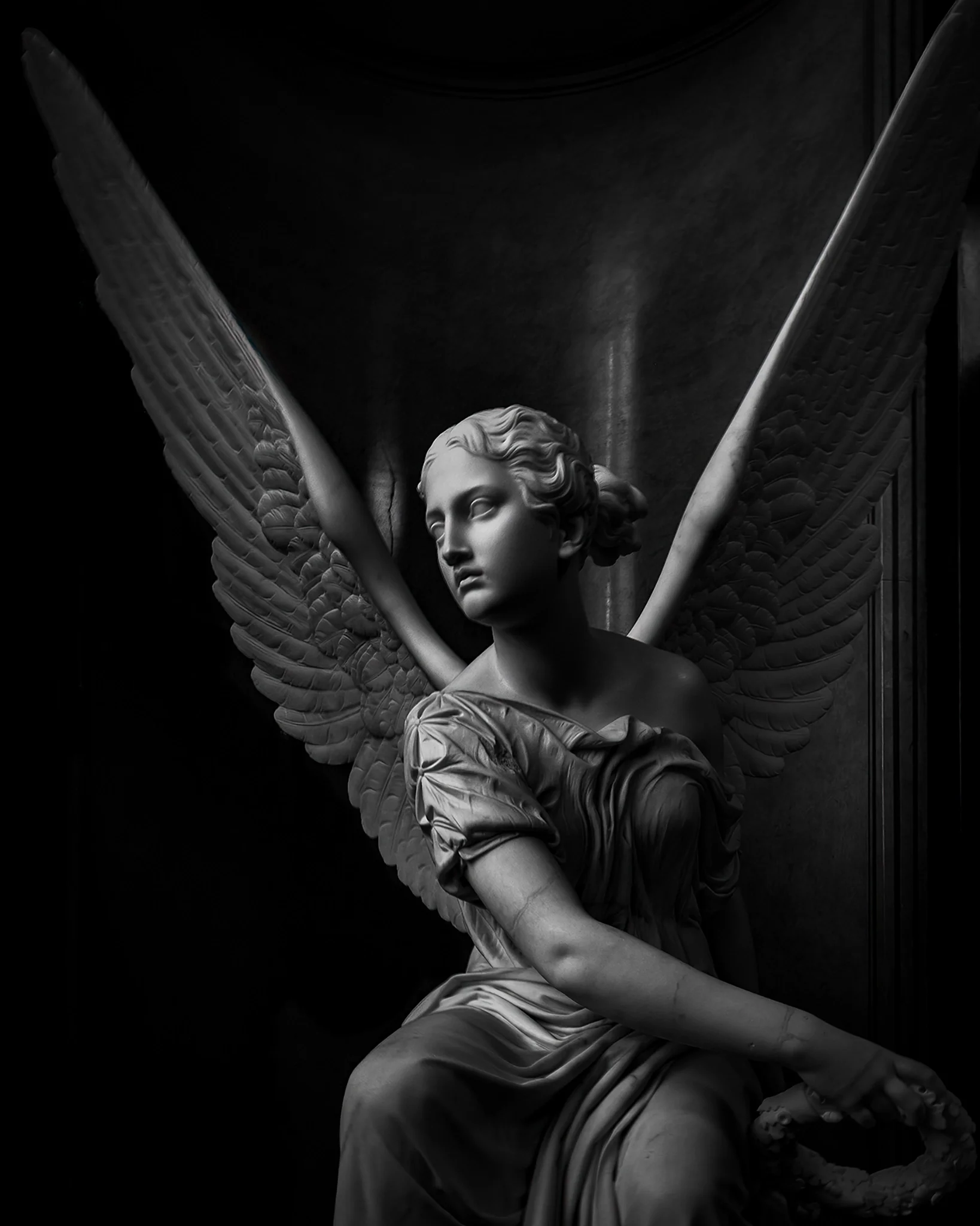 Seated Victoria Throwing a Wreath — marble sculpture, angelic wings, serene face, flowing drapery, black and white