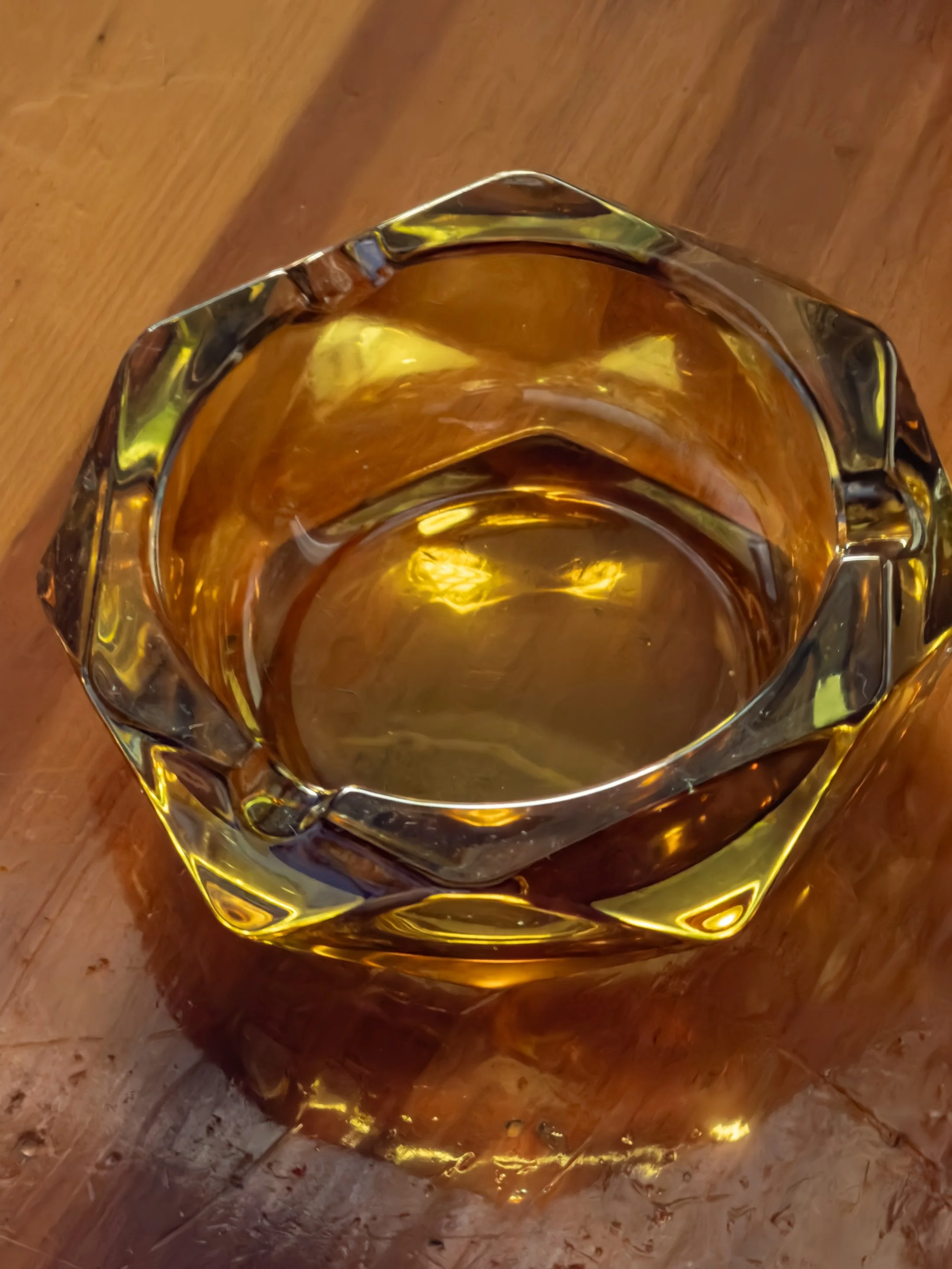 view of a glass pitcher filled with a golden-brown liquid on a wooden surface.